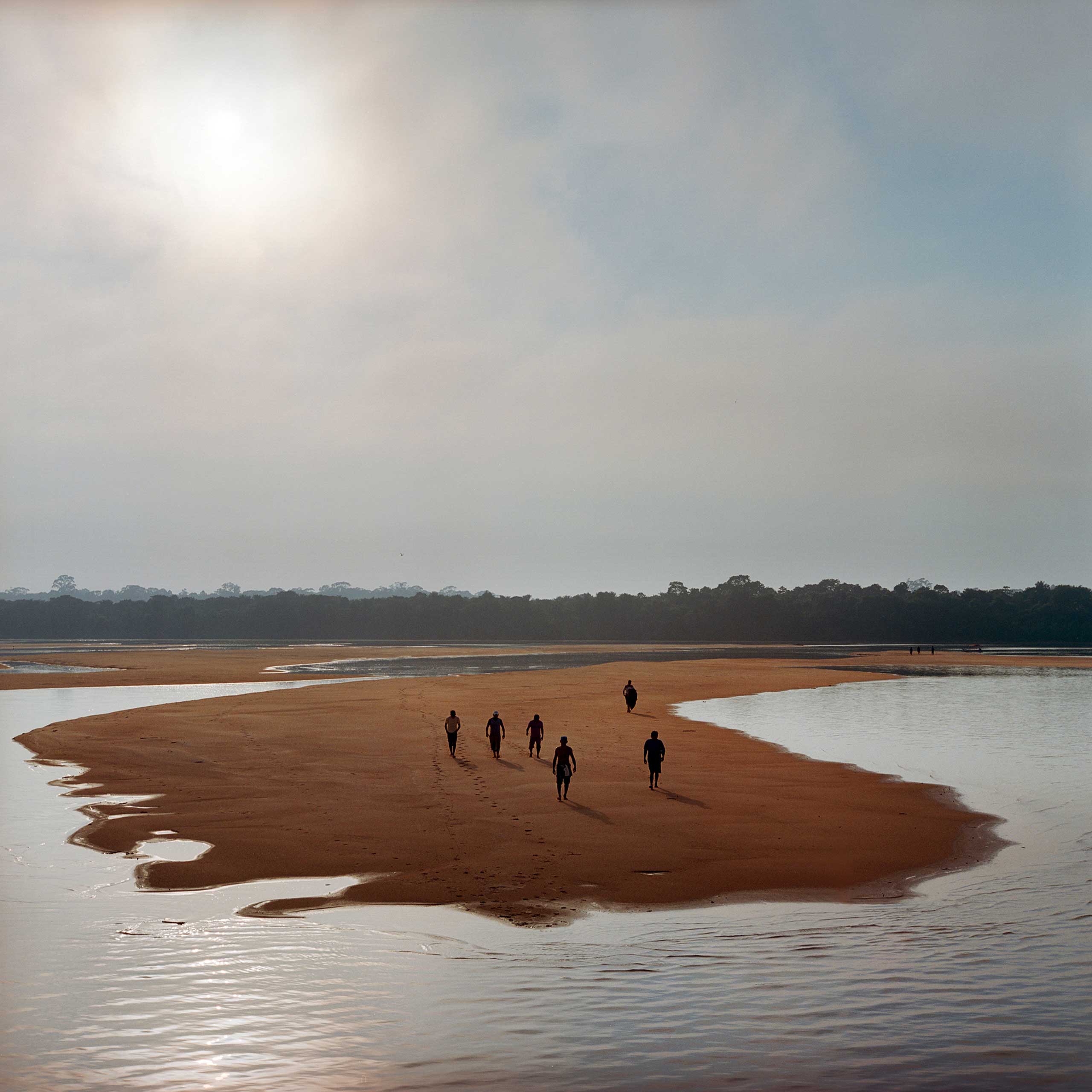 Members of the Munduruku indigenous tribe walk on a sandbar on the Tapajos River as they prepare for a protest against plans to construct a series of hydroelectric dams on the river in the Amazon rainforest in Para State, Brazil. The tribe members used the rocks to write 'Tapajos Livre' (Free Tapajos) in a large message in the sand in an action in coordination with Greenpeace. The Munduruku live traditionally along the river and depend on fishing and the river system for their livelihood. As their traditional lands are unrecognized by the government, they have little legal protection against development, but have vowed to fight against the dams, Nov. 2014.