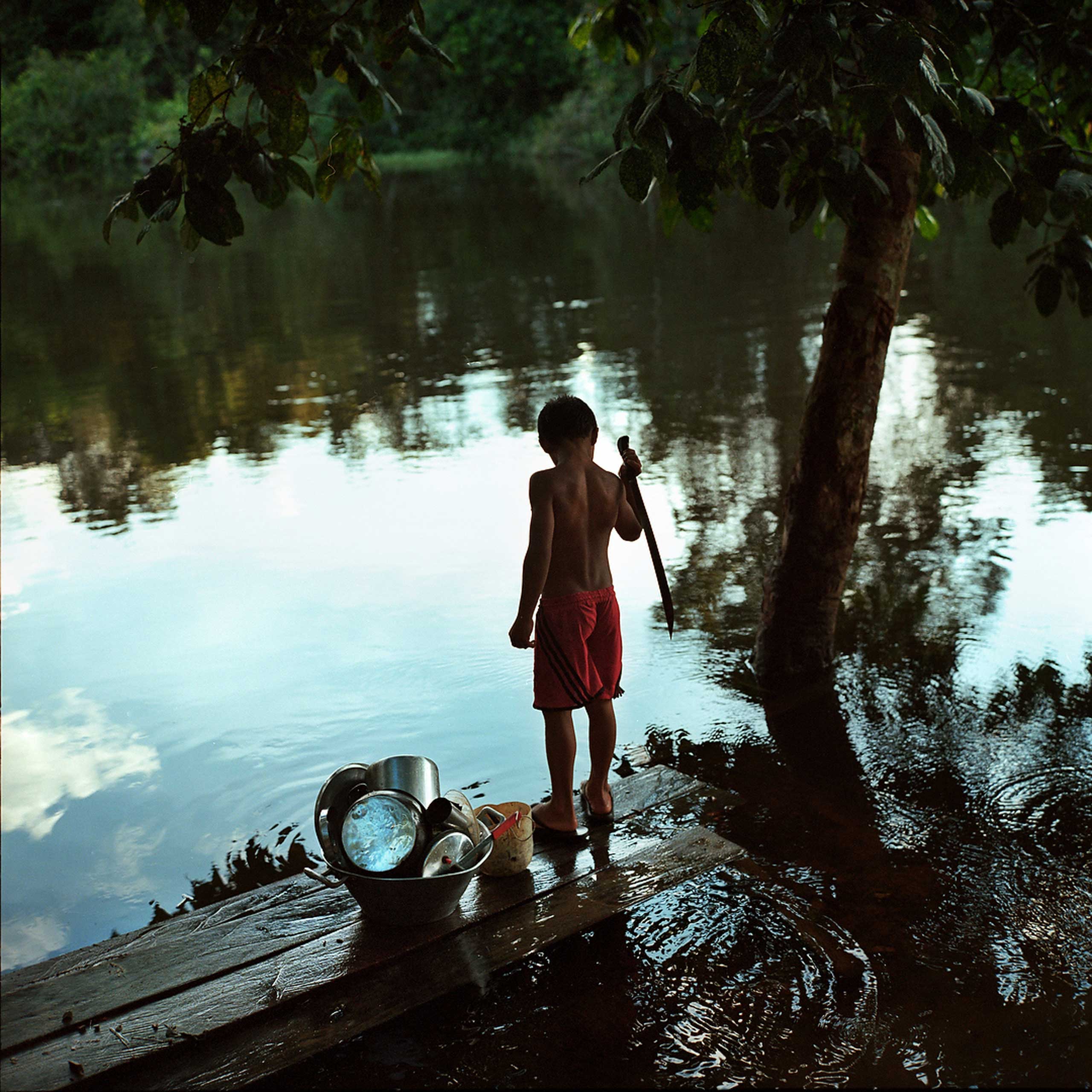 A boy plays by the river on the Extractavist Reserve of Riozinho do Anfrísio in the Xingu Basin. Descendants of the Rubber Tapers who came to the forests during Brazils Rubber Boom, Extractavists see themselves as the protectors of the forest, fighting ranchers and loggers for the preservation of their land. Throughout the Amazon they are being threatened by development, April 2014.