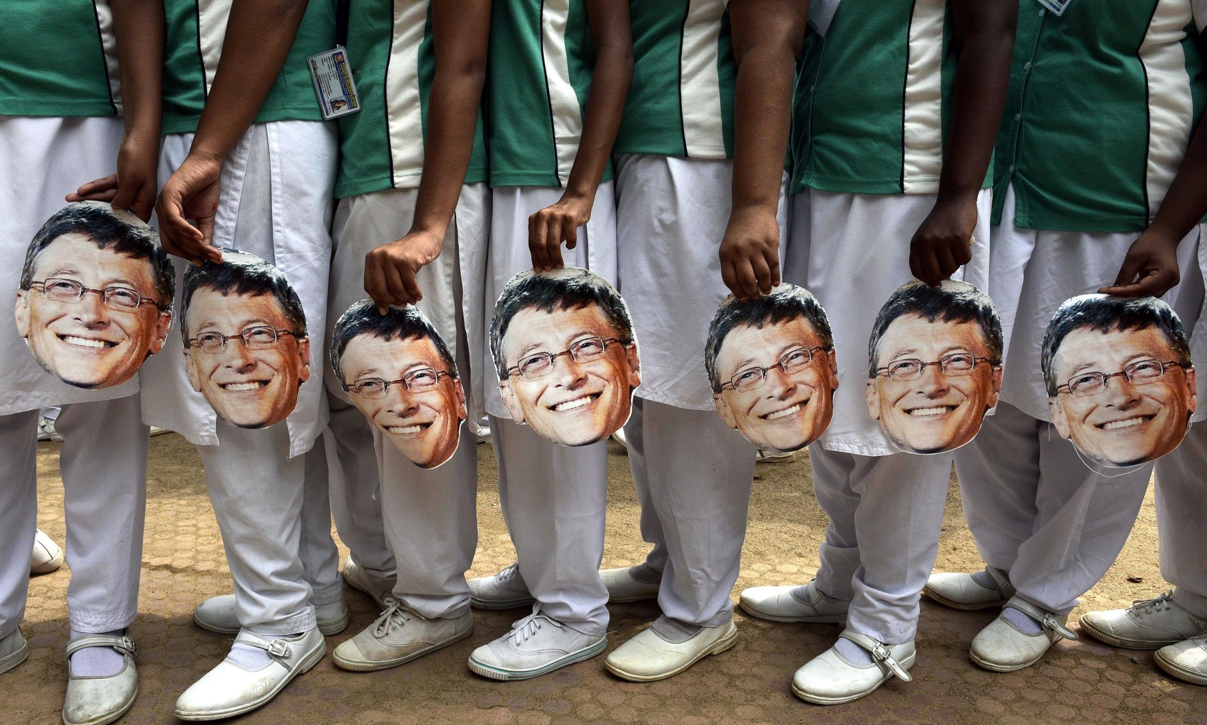Indian schoolchildren hold Bill Gates masks.