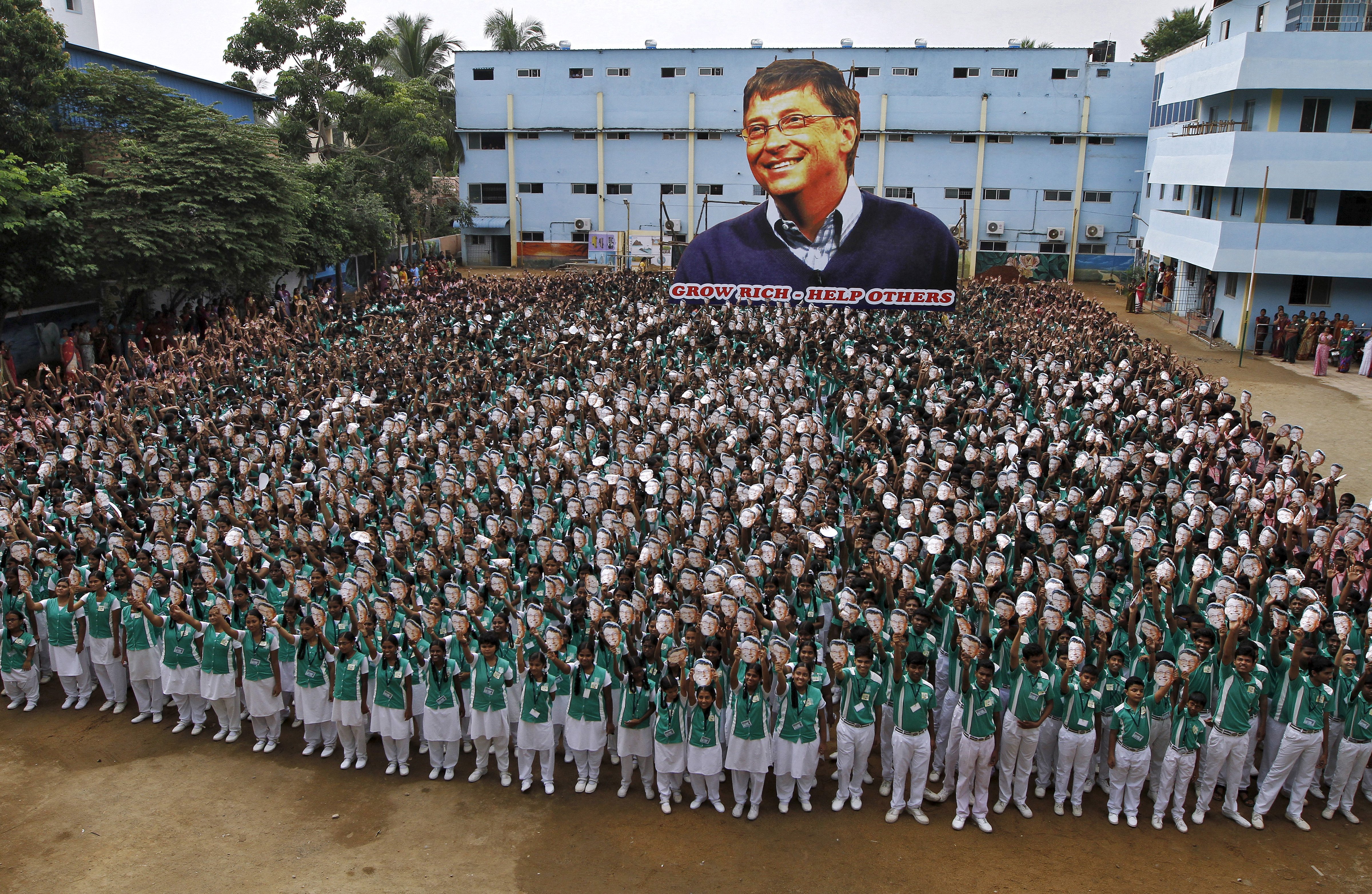 School children hold portraits of Microsoft co-founder Bill Gates in front of a giant picture of Gates during celebrations to mark his 60th birthday inside the school premises in Chennai, India on Oct. 28, 2015.