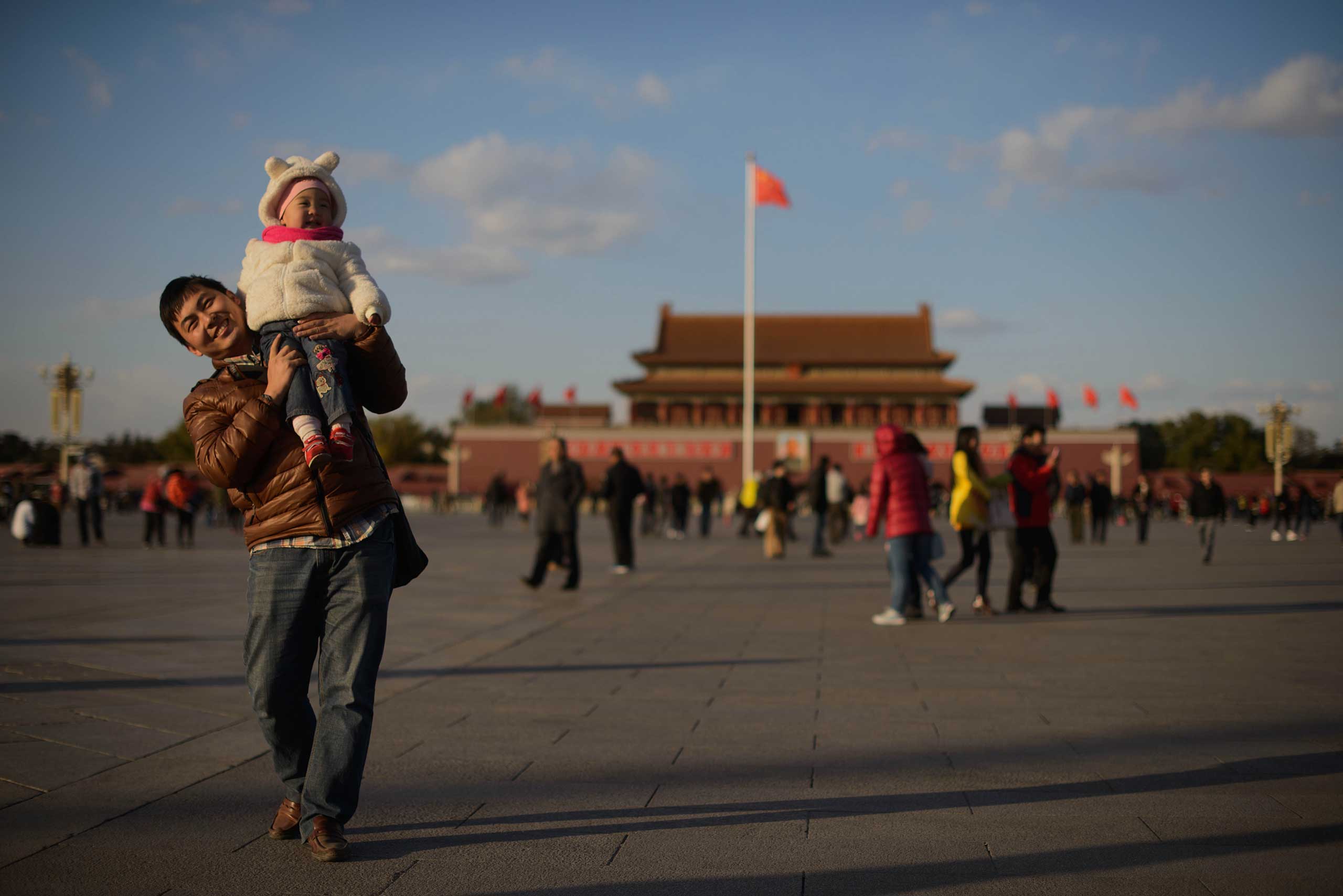 A man and child walk on Tiananmen Square in Beijing in 2013. (Ed Jones—AFP/Getty Images)