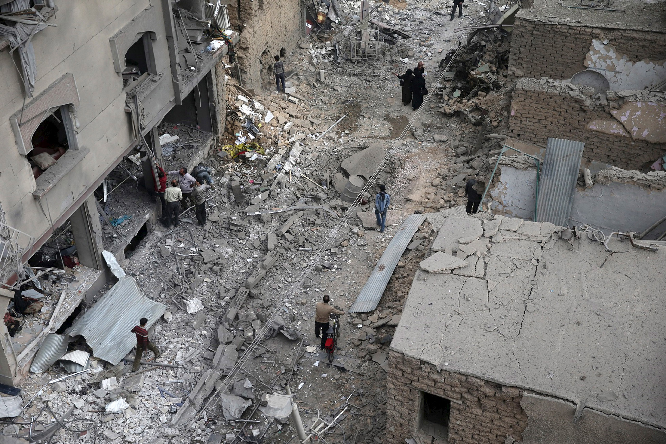 Residents inspect damage from what activists said was an airstrike by forces loyal to Syria's President Bashar al-Assad on the main field hospital in the town of Douma, north-east of Damascus, on Oct. 29, 2015. (Bassam Khabieh—Reuters)