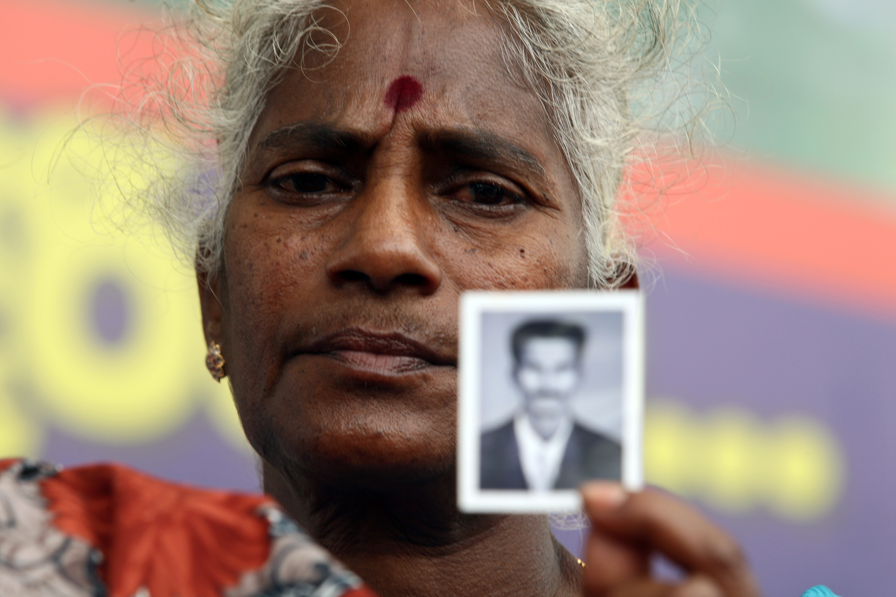 Senevirathnam Wasanayagi, 63, mother of a detained Tamil Tiger rebel suspect holds up a photo of her son during a protest outside the main prison on May 29, 2012, in Colombo, Sri Lanka. Relatives and rights activists are demanding that the Tamil Tiger rebel suspects who have been held without trial  are released or brought to court (Buddhika Weerasinghe—Getty Images)