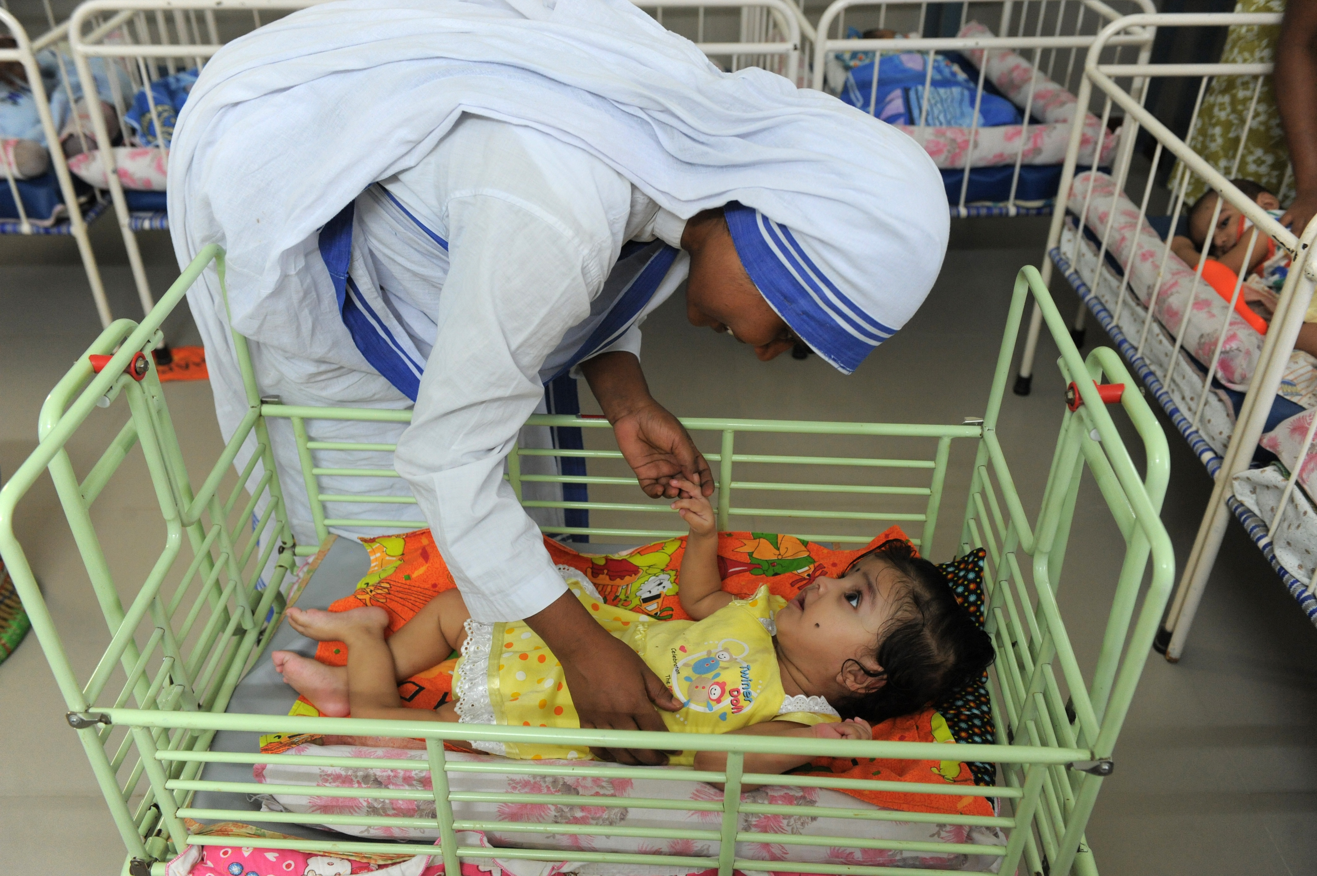 A Christian nun plays with an orphan at Shishu Bhavan, orphanage for discarded babies run by The Missionaries of Charity in Ahmedabad, India, on Sept. 4, 2013. (Sam Panthaky—AFP/Getty Images)