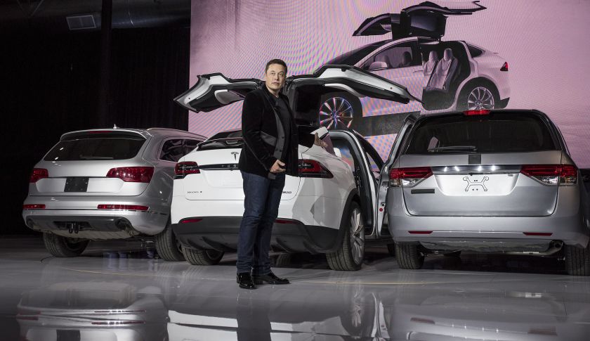 Elon Musk, chairman and CEO of Tesla Motors, demonstrates the ‘falcon-wing’ doors of the Model X during an event in Fremont, Calif. (Bloomberg&mdash;Bloomberg via Getty Images)