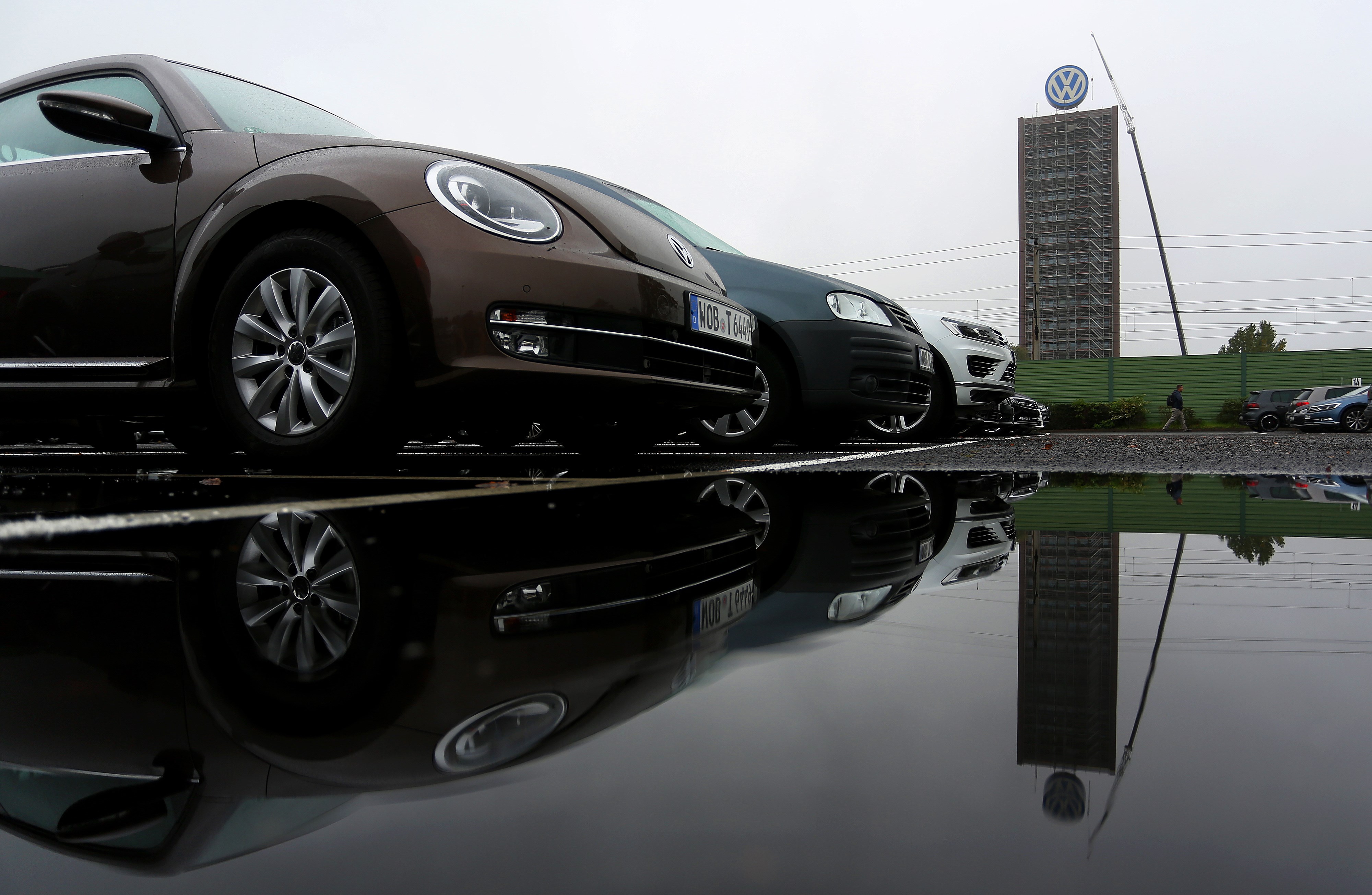The logo of German carmaker Volkswagen and cars reflect on a rain puddle near the company's headquarters in Wolfsburg, central Germany, on Oct. 8, 2015 (Ronny Hartmann—AFP/Getty Images)