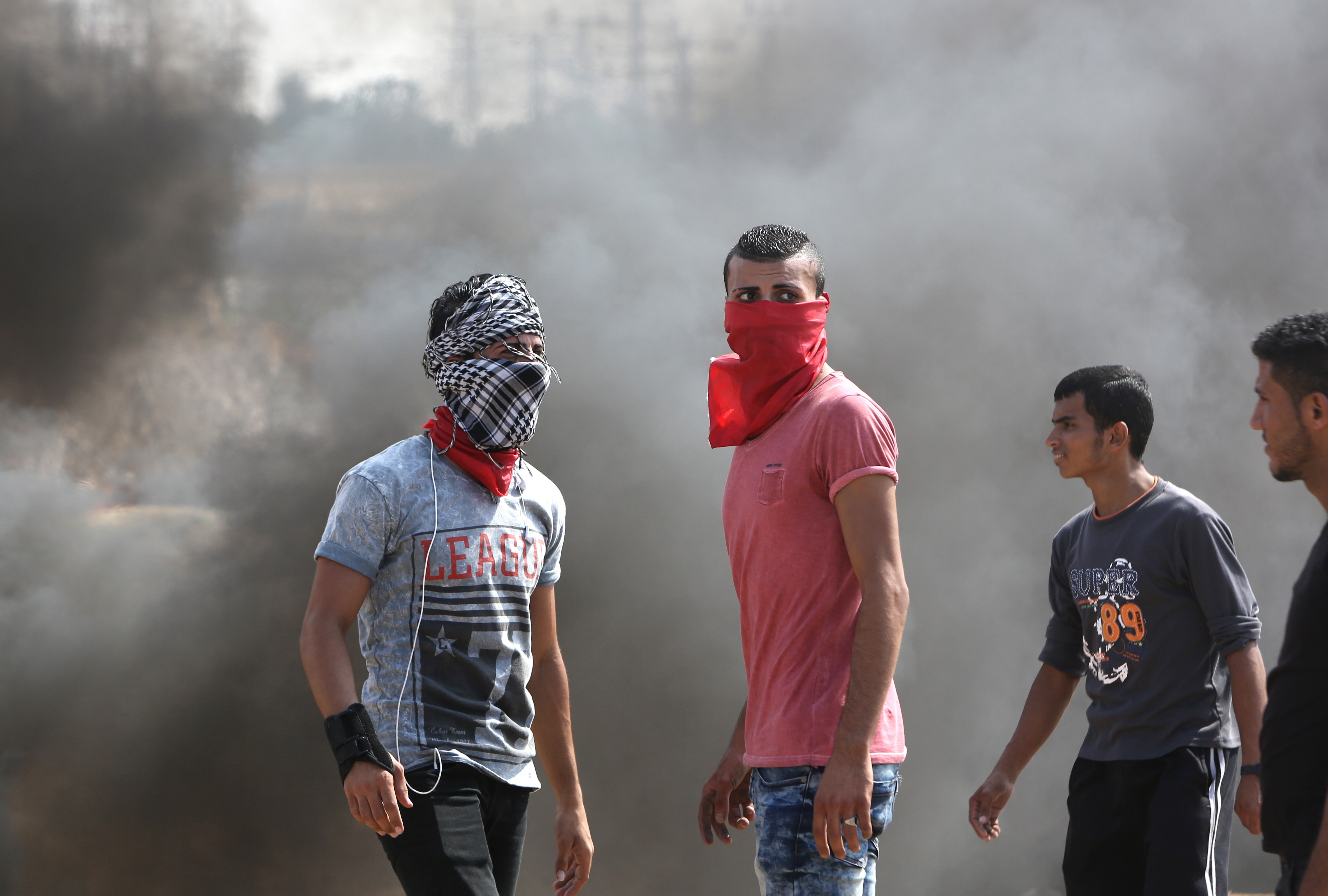 Palestinian protesters stand amid smoke during clashes with Israeli security forces near the Nahal Oz border crossing with Israel, east of Gaza City on Oct. 10, 2015. (Mahmud Hams—AFP/Getty Images)