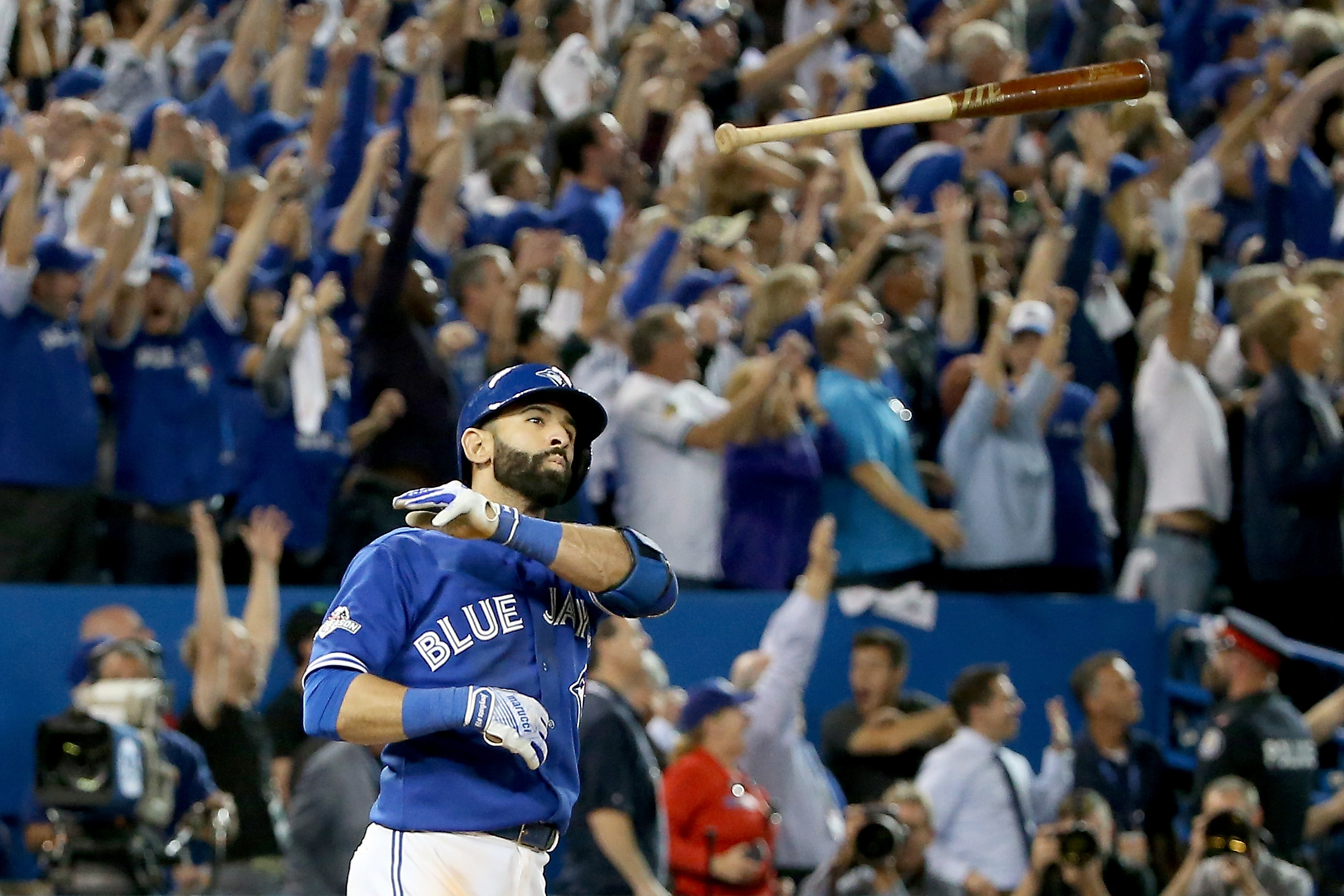 Jose Bautista #19 of the Toronto Blue Jays throws his bat up in the air after he hits a three-run home run in the seventh inning against the Texas Rangers in game five of the American League Division Series at Rogers Centre on October 14, 2015 in Toronto, Canada. (Tom Szczerbowski—Getty Images)