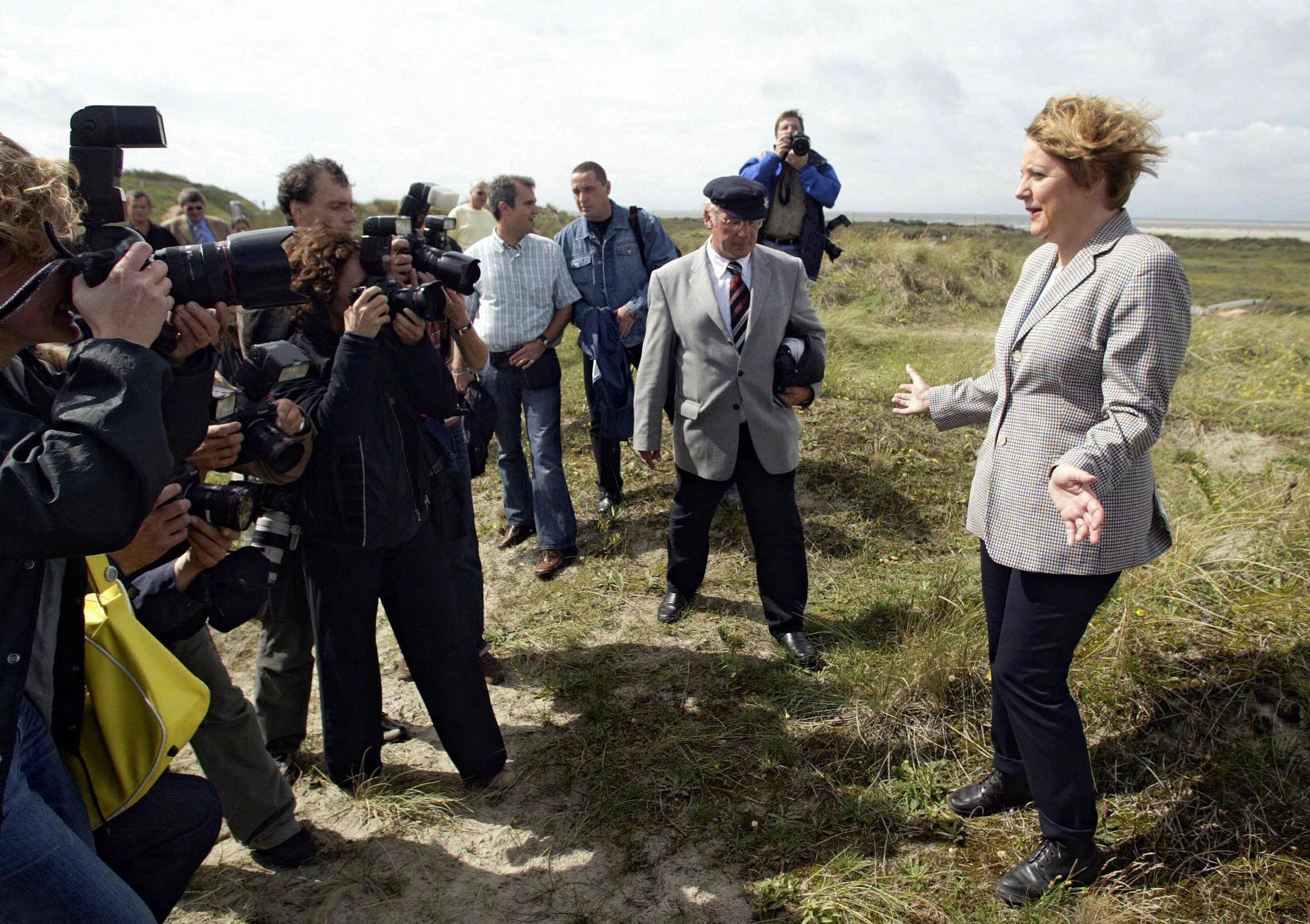 Angela Merkel stands on a dune as she poses for photographers during a visit to the North Sea island of Borkum, Germany, in 2004.