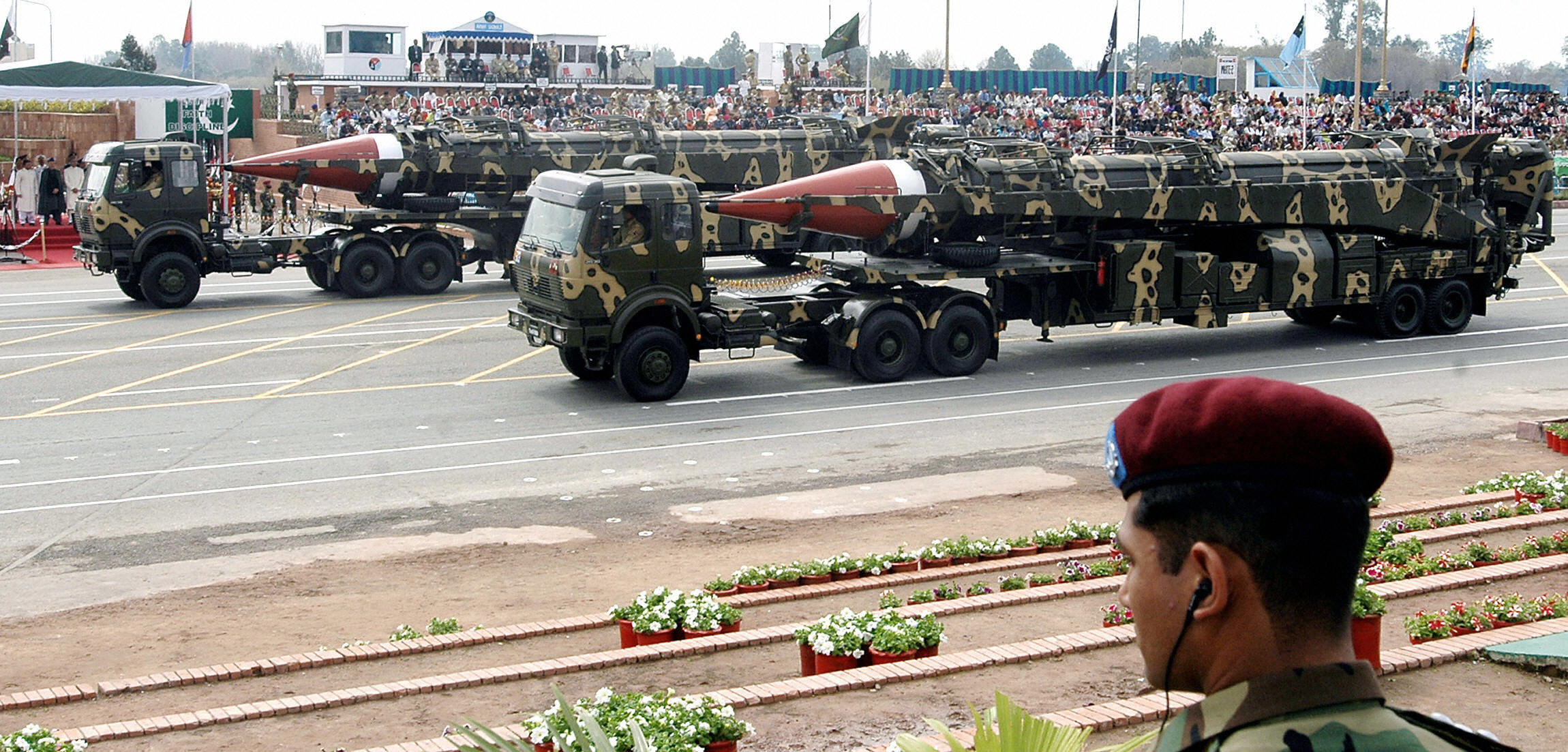 A Pakistani commando (R) looks on as Ghauri intermediate-range missiles capable of carrying nuclear warhead are transported on launchers during the National Day parade in Islamabad, 23 March 2005. (FAROOQ NAEEM—AFP/Getty Images)