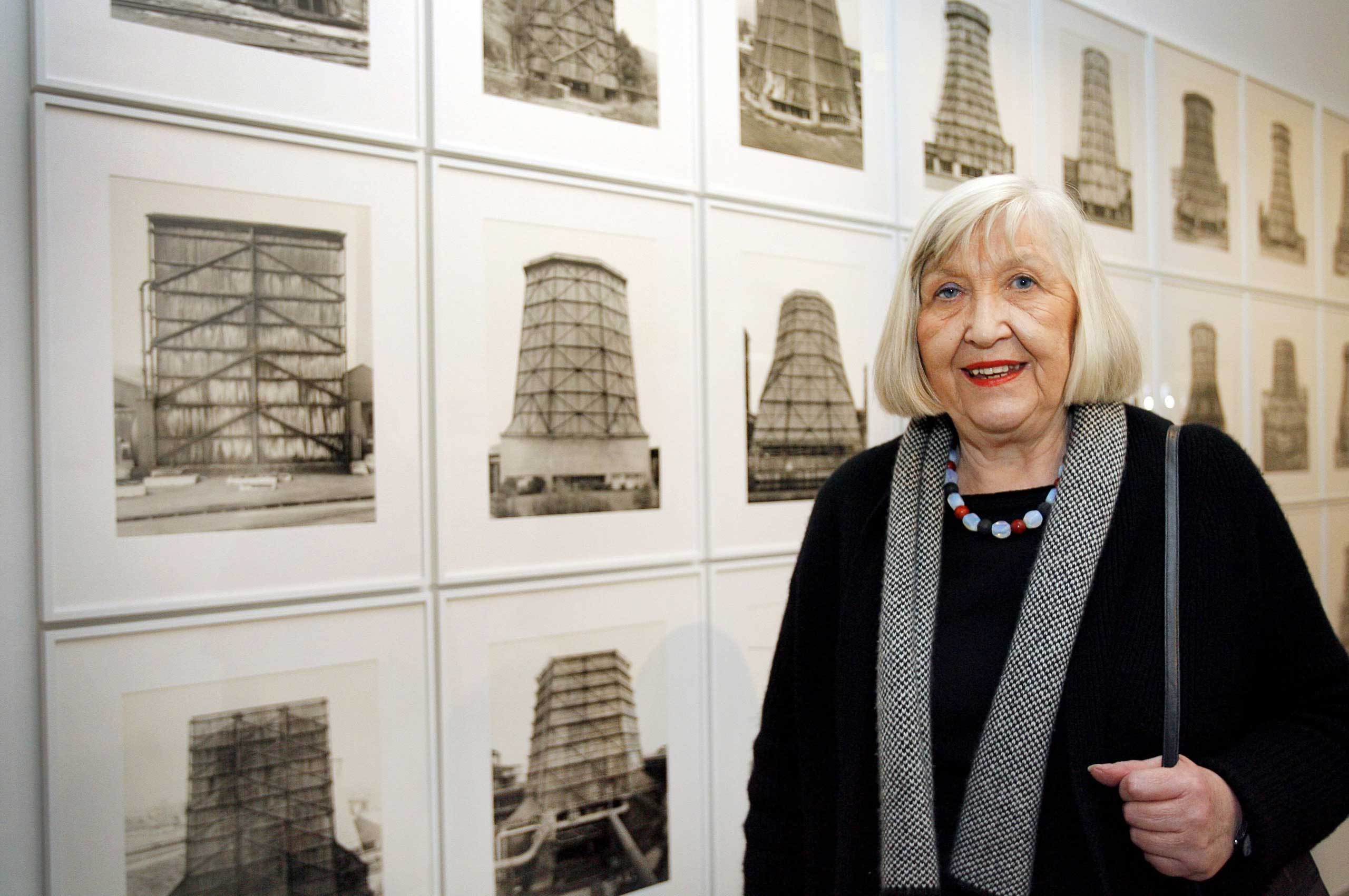 German photographer Hilla Becher posing next to her photo series "Cooling Towers" at the Musee d'Art Moderne de la Ville in Paris, France, on Oct. 2, 2008. (David Ebener—EPA)