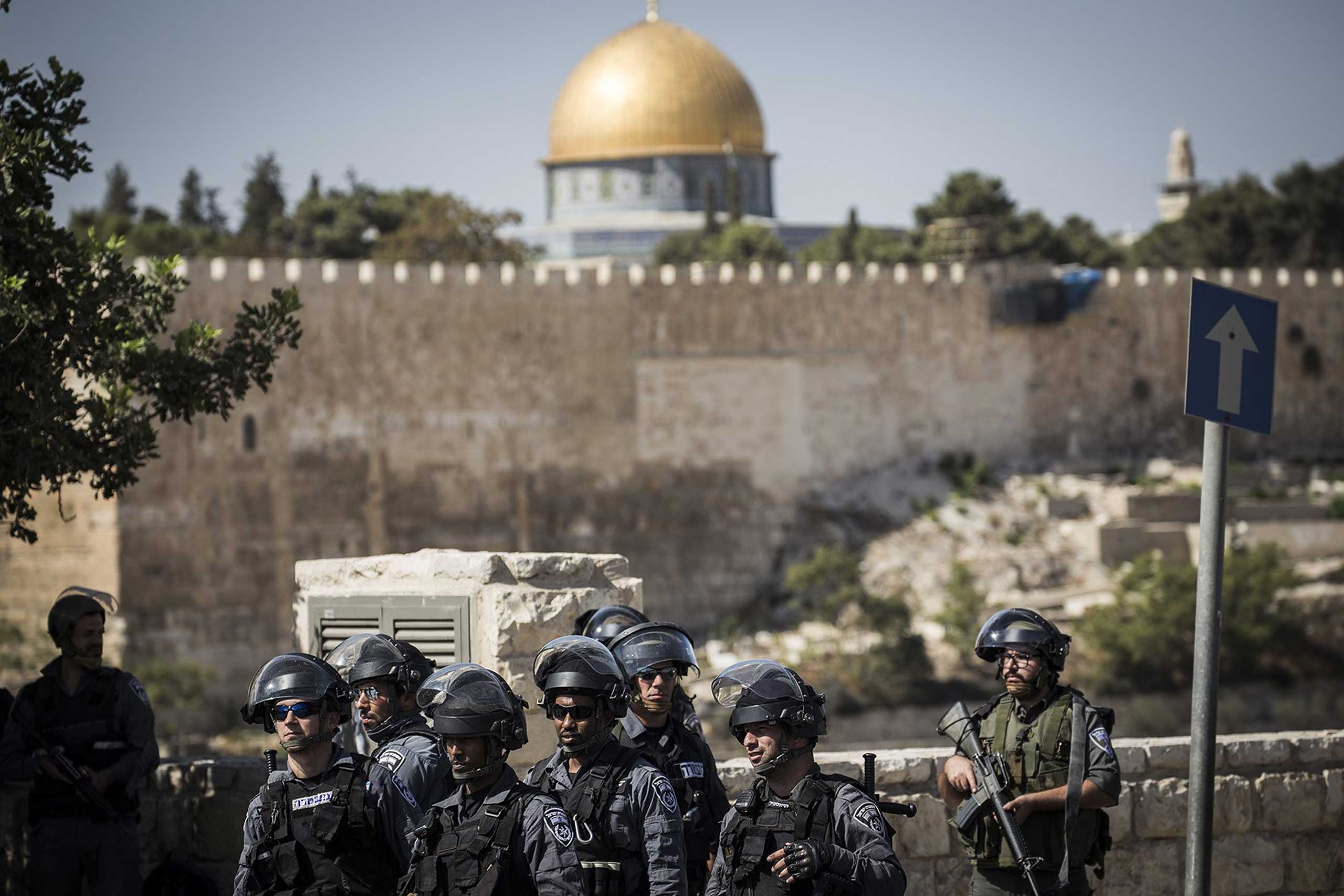 Israeli security forces look on during a noon Friday prayer outside Ras Al Amud neighborhood in Jerusalem, on Oct. 16, 2015. (Ilia Yefimovich—Getty Images)