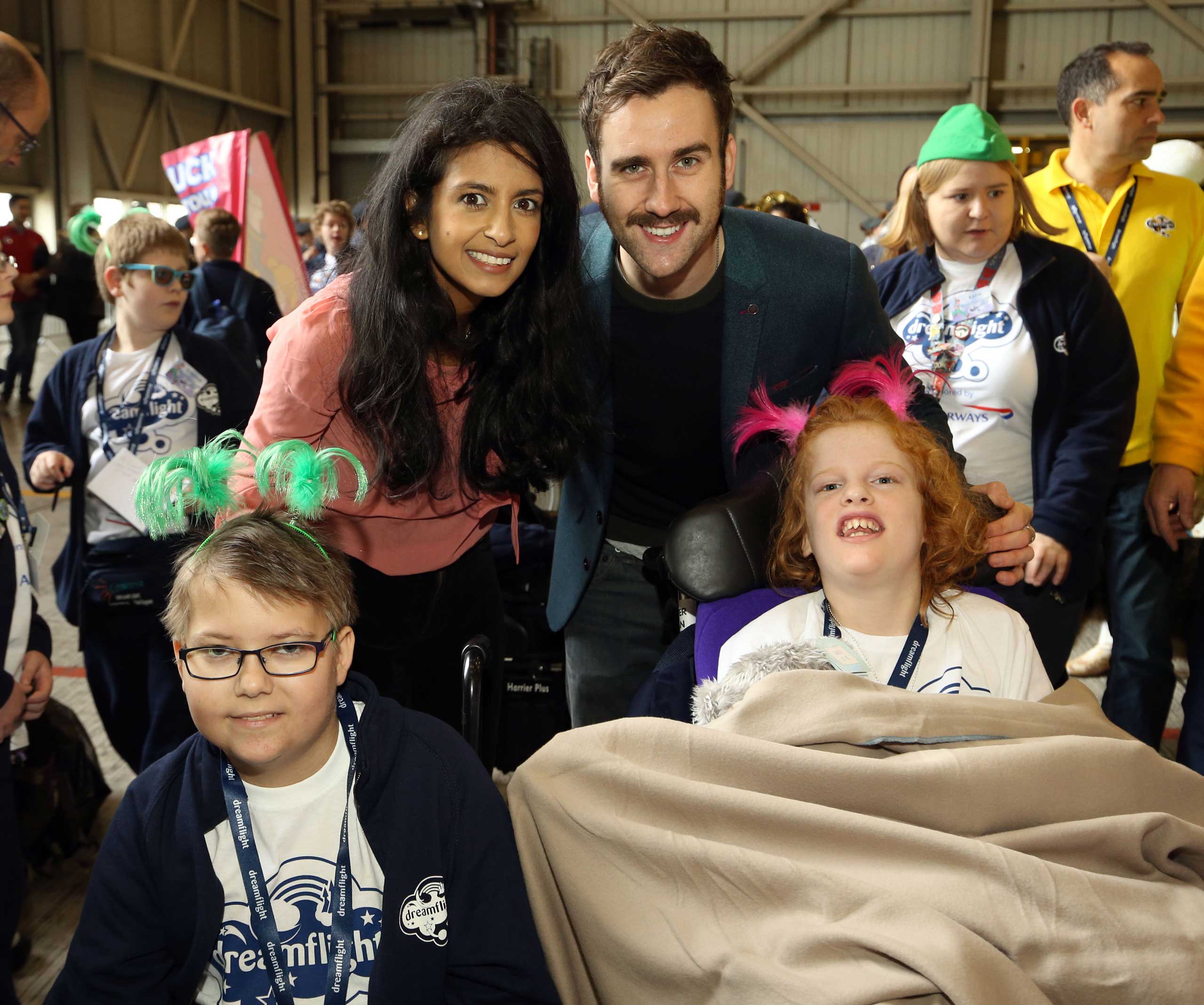 Konnie Huq (centre left) and Matthew Lewis (centre right), as the Dreamflight children are sent off on their trip from Heathrow Airport in London to Orlando in Florida, Oct. 18, 2015. (Steve Parsons—AP Images)