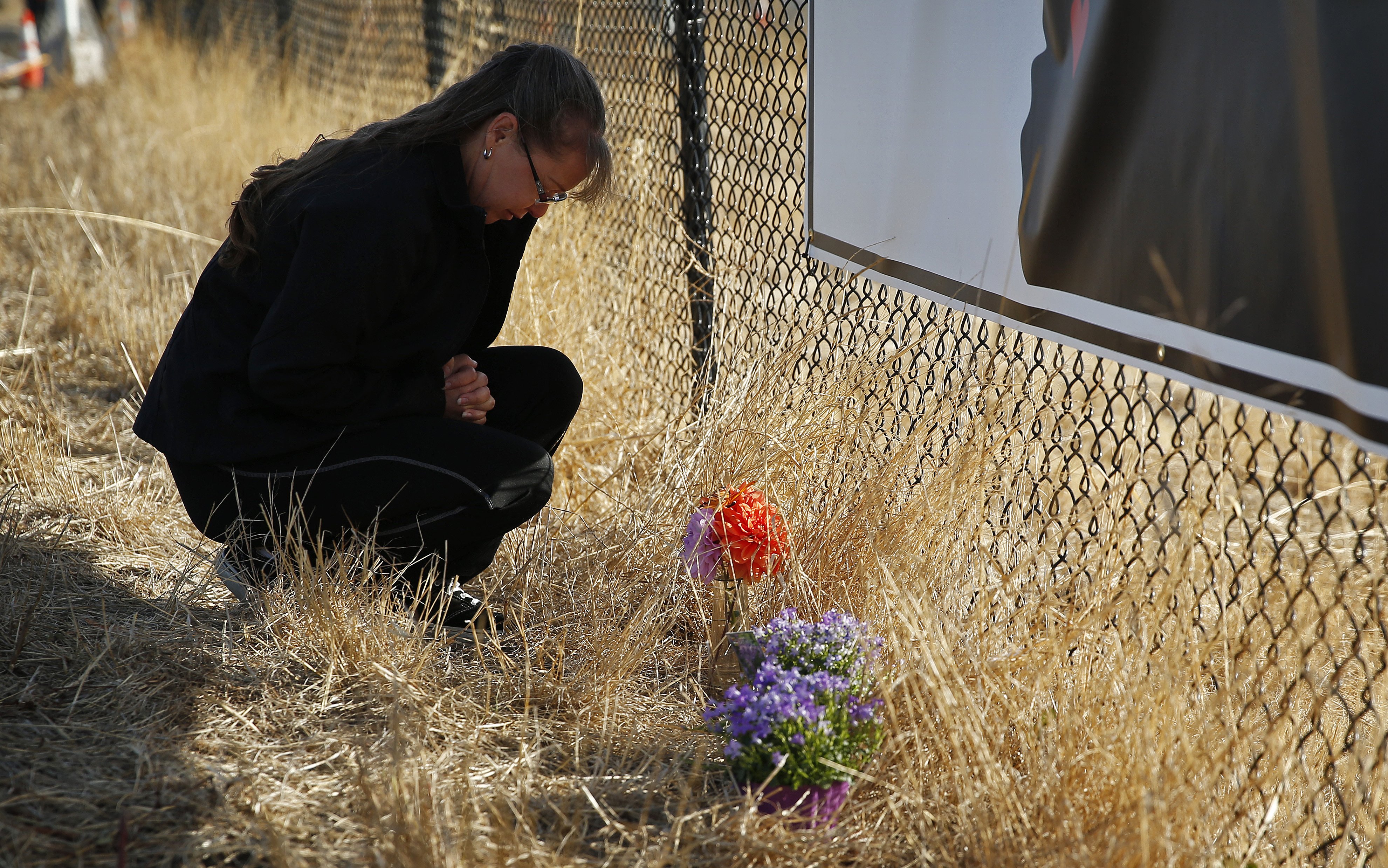 Robin Griffiths, of Portland, prays at a makeshift memorial near the road leading to Umpqua Community College on Oct. 3, 2015, in Roseburg, Ore. (John Locher—AP)
