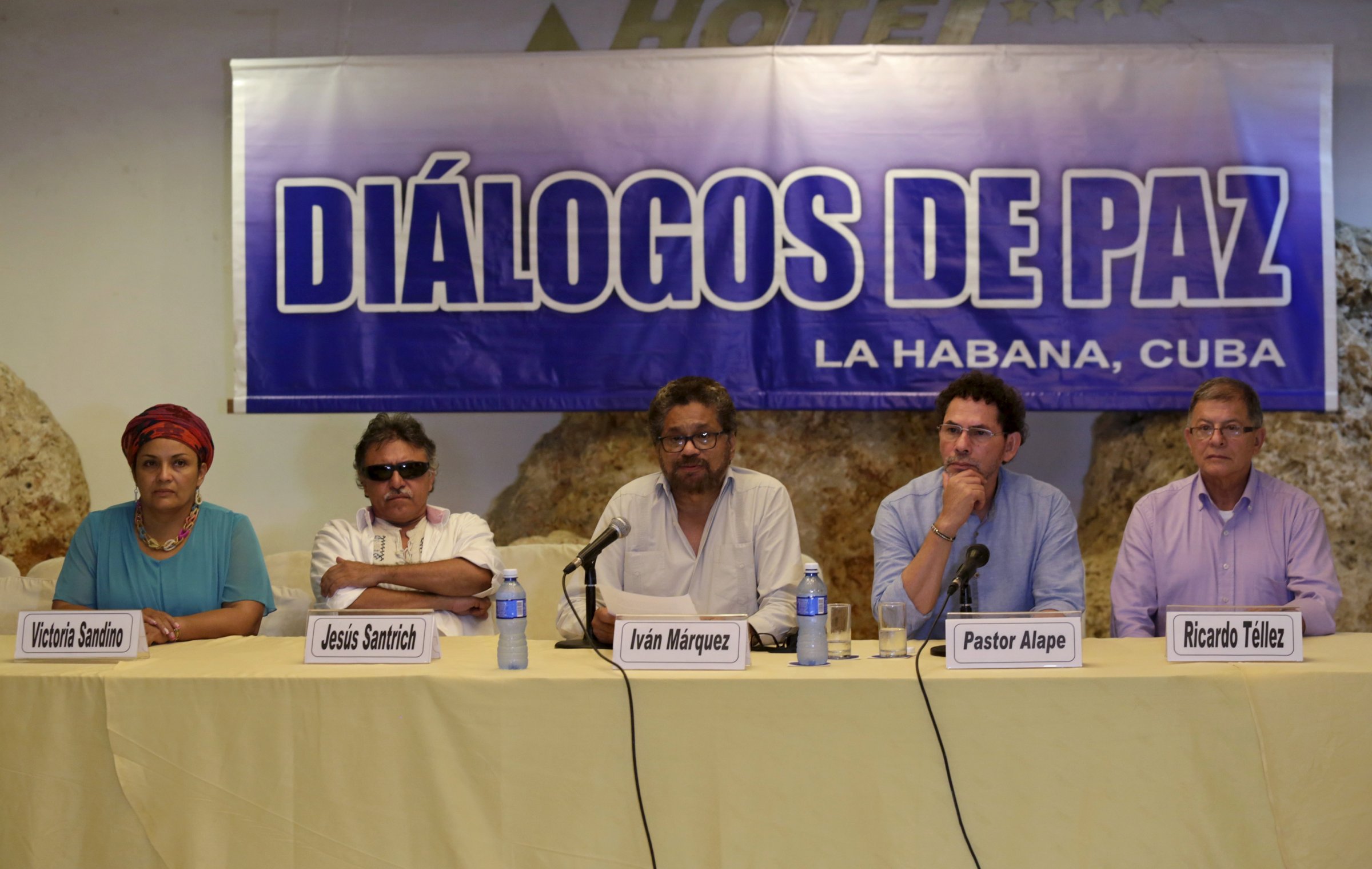 FARC lead negotiator Ivan Marquez reads a document while flanked by fellow FARC members in Havana