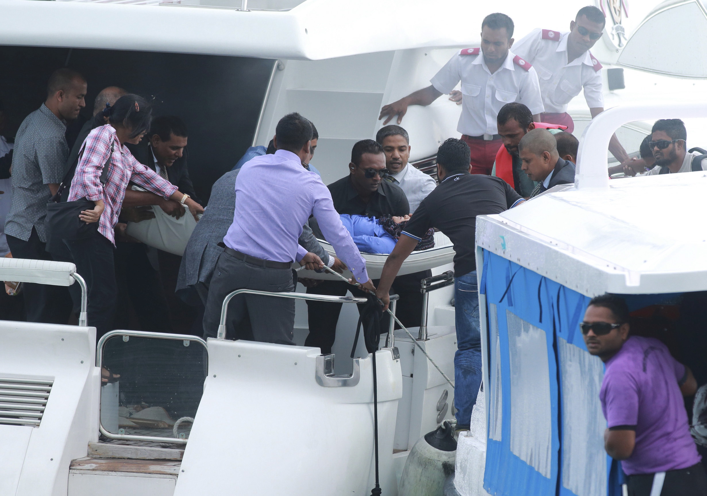 Officials carry an injured woman off the speed boat of Maldives President Abdulla Yameen after an explosion onboard, in Male, Maldives
