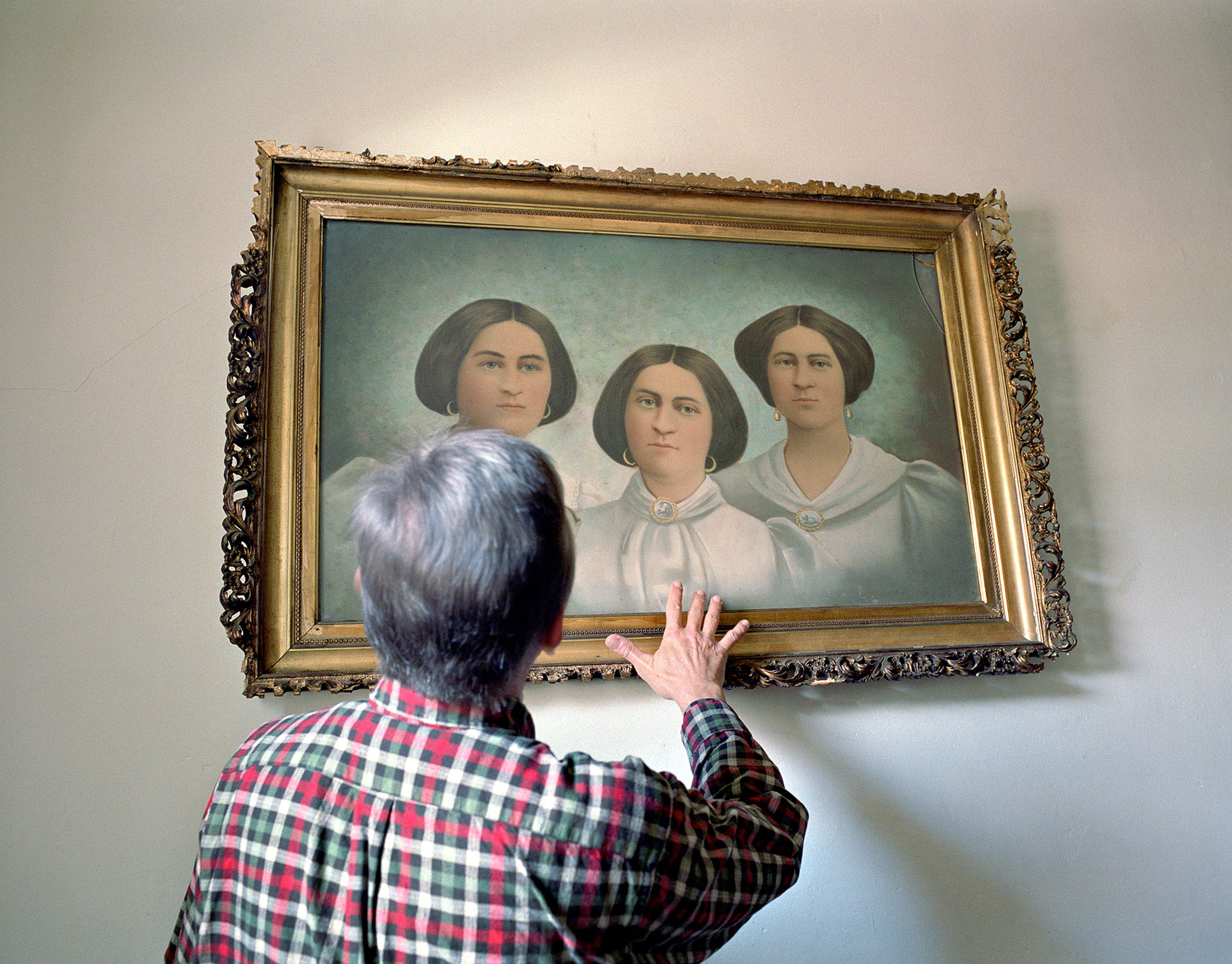 Lily Dale historian Ron Nagy with a painting of the Fox sisters, founders of Spiritualism.