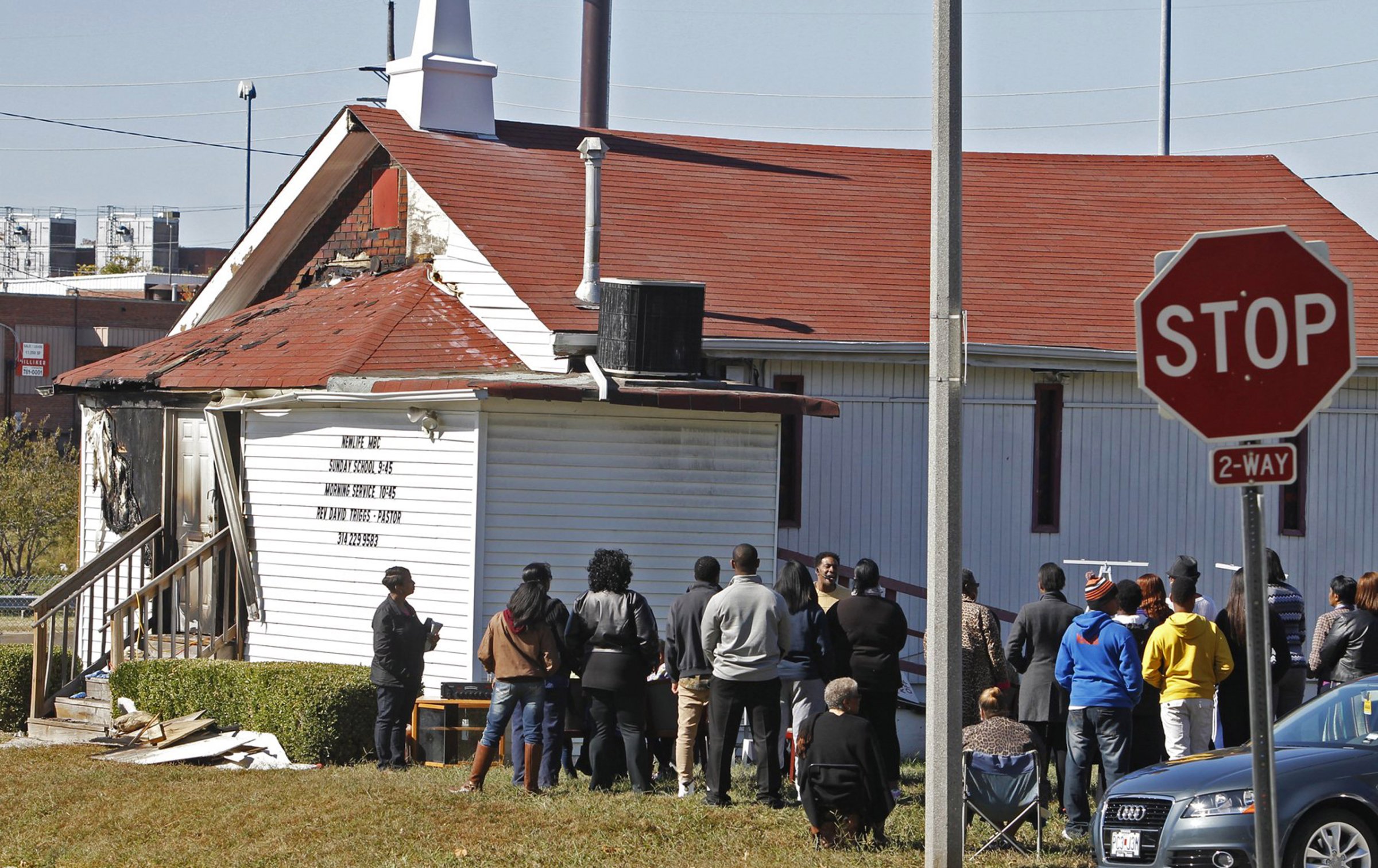 In this Sunday, Oct. 18, 2015 photo, an outdoor service is held following a fire at the New Life Missionary Baptist Church in St. Louis. Someone has been setting fire to predominantly black churches in the St. Louis area, and investigators are trying to determine if the arsonist is targeting either religion or race. (J.B. Forbes/St. Louis Post-Dispatch via AP) EDWARDSVILLE INTELLIGENCER OUT; THE ALTON TELEGRAPH OUT; MANDATORY CREDIT