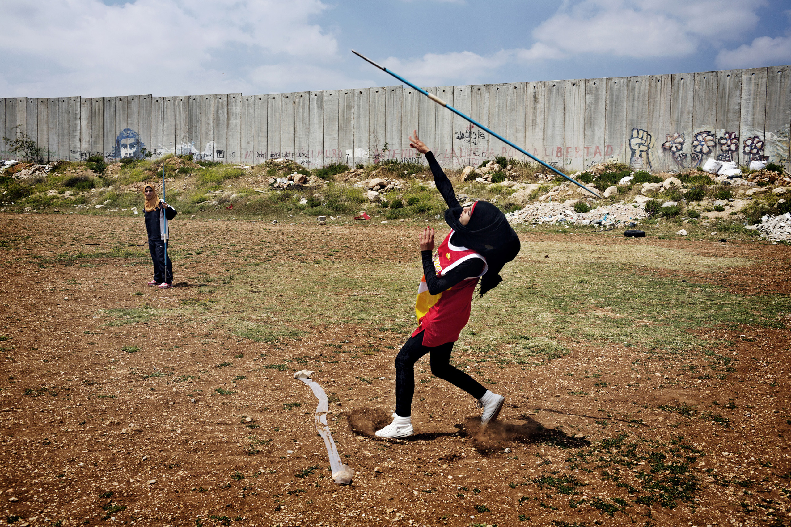 Students from the Al-Quds University javelin team wrap up the last practice before summer vacation in the West Bank city of Abu Dis, next to the Israeli Separation Wall.