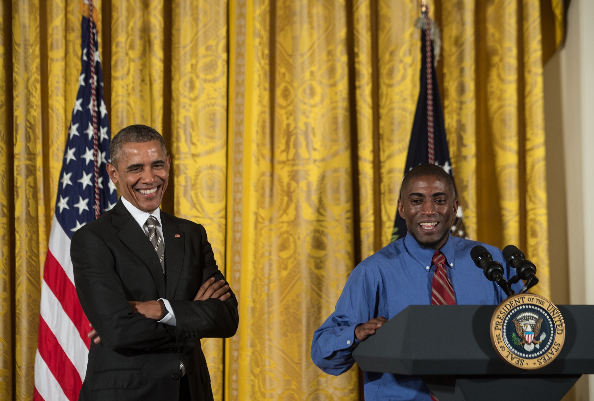 US President Barack Obama (L) smiles as he is introduced by fast food worker Terrence Wise at the Summit on Worker Voice at the White House in Washington, DC, on Oct. 7, 2015.
