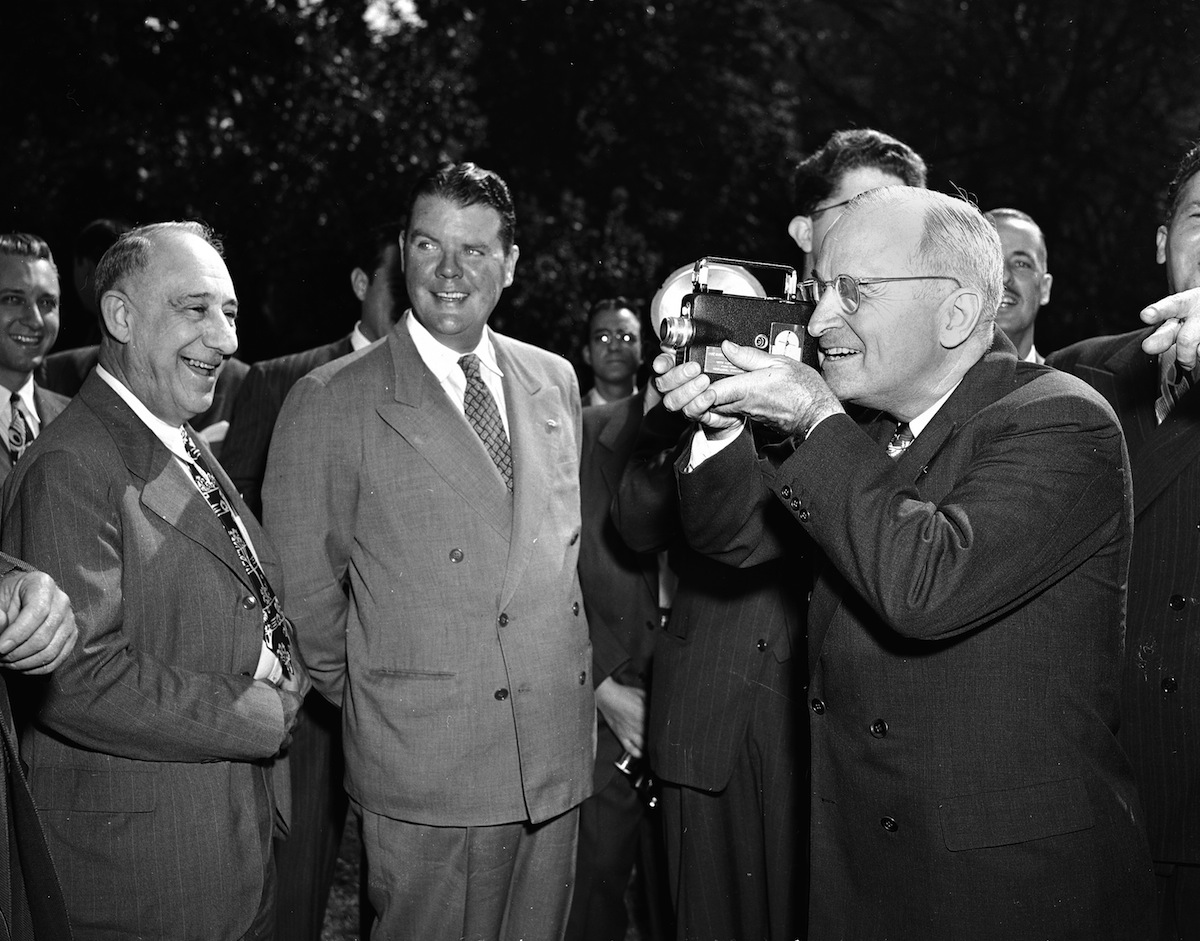 President Harry Truman operates a movie camera during a picture-taking session on the south grounds of the White House, Oct. 5, 1947. (Harvey Georges—AP)
