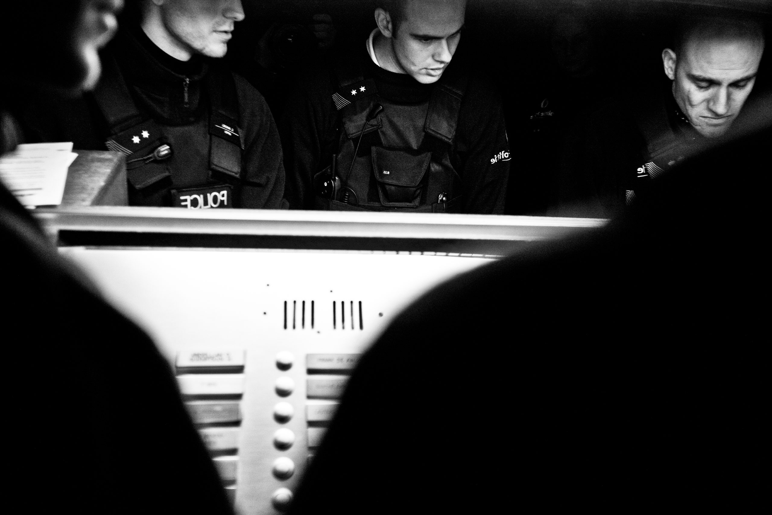Policemen search apartment numbers on the intercom of a building in Molenbeek, Brussels, Belgium on Feb 1, 2010.