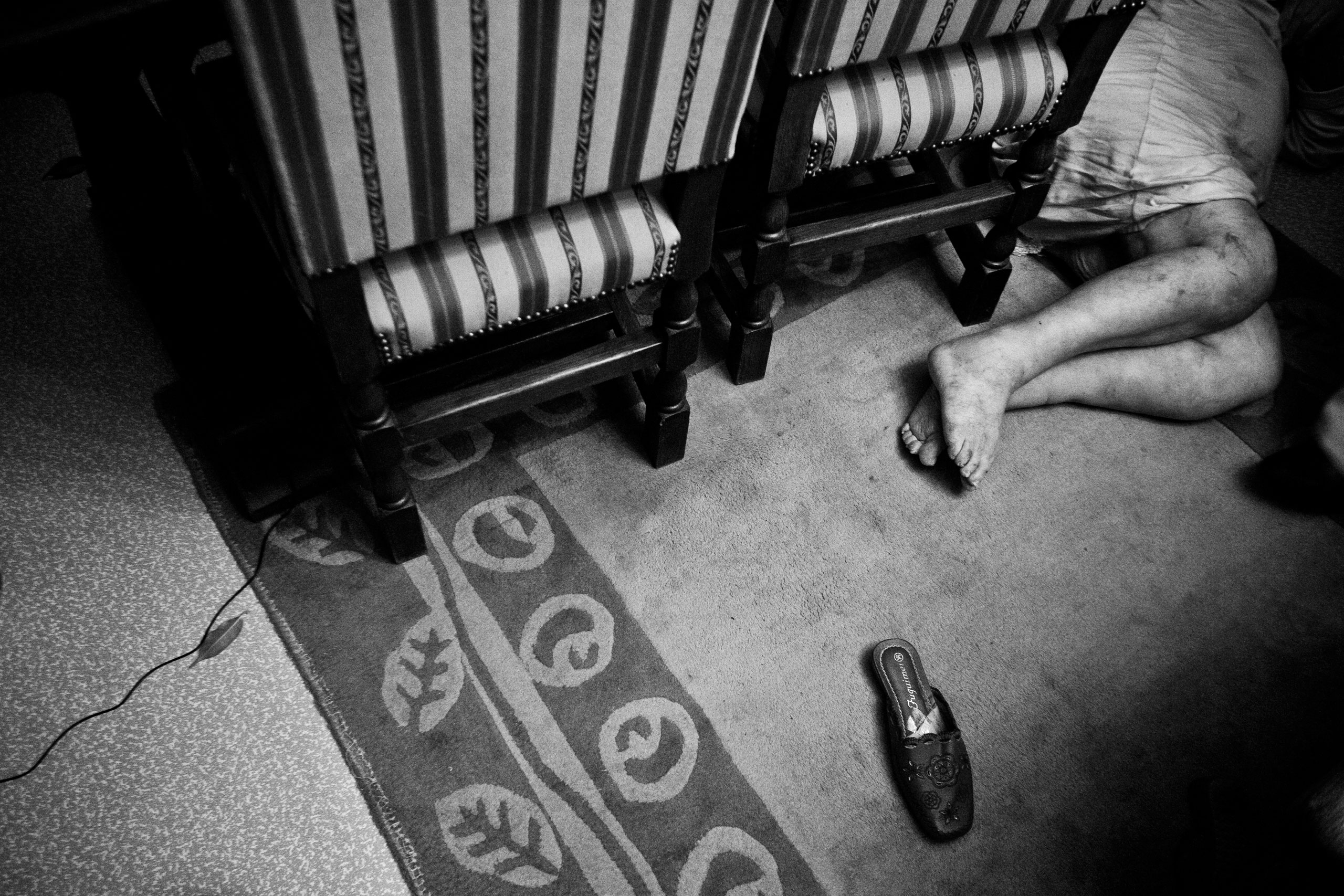 An old woman lays on the floor of her apartment in Molenbeek, Belgium, Feb. 25, 2010. The police was called for an unresponsive old woman, who fell from a chair and couldn't wake up.