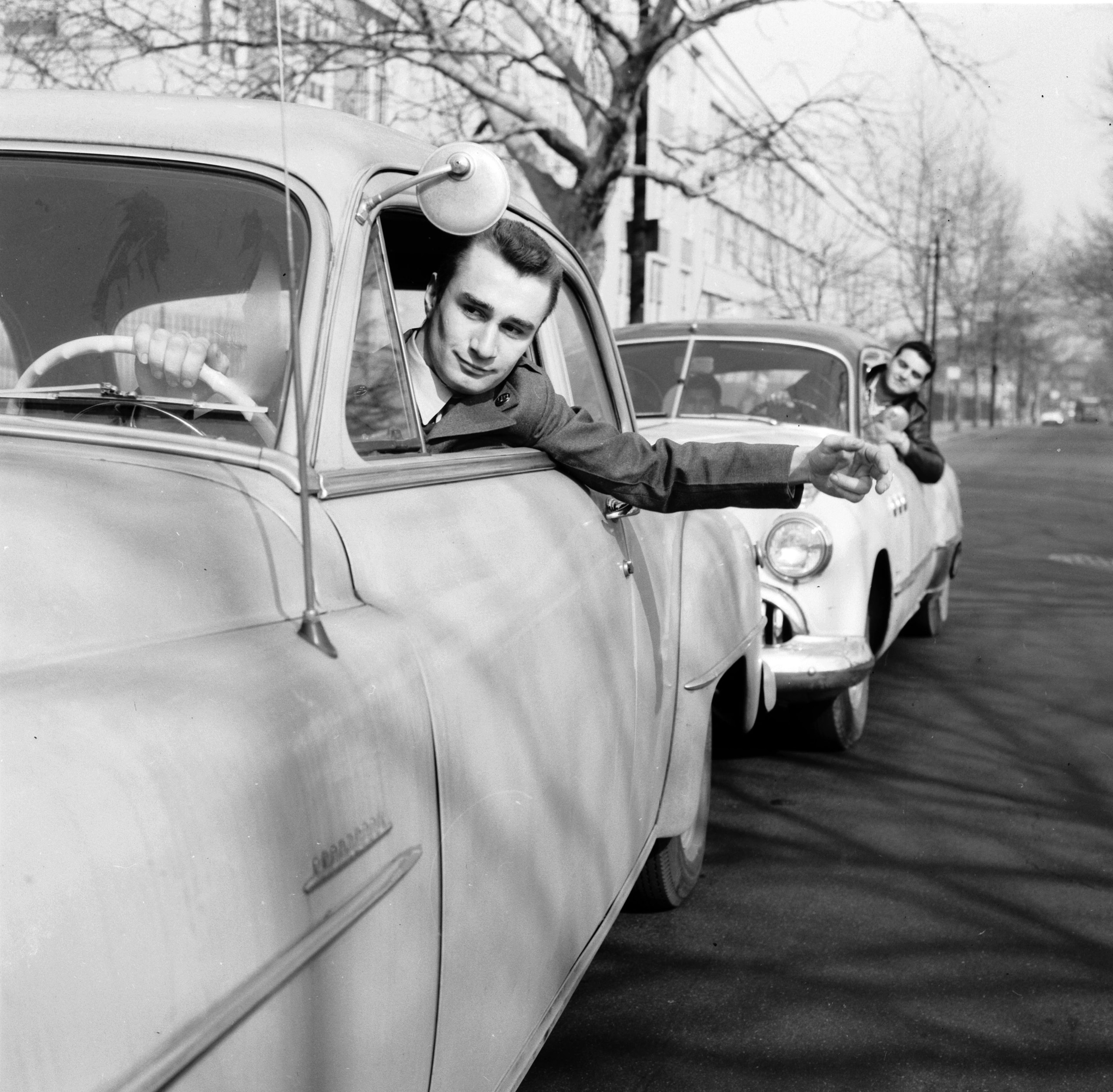 Students at Brooklyn School of Automotive Trades and members of the Automotive Custom Crafters Club are pledged to provide honest service to the motoring public without charge. Here they give a driver a push start, 1956.