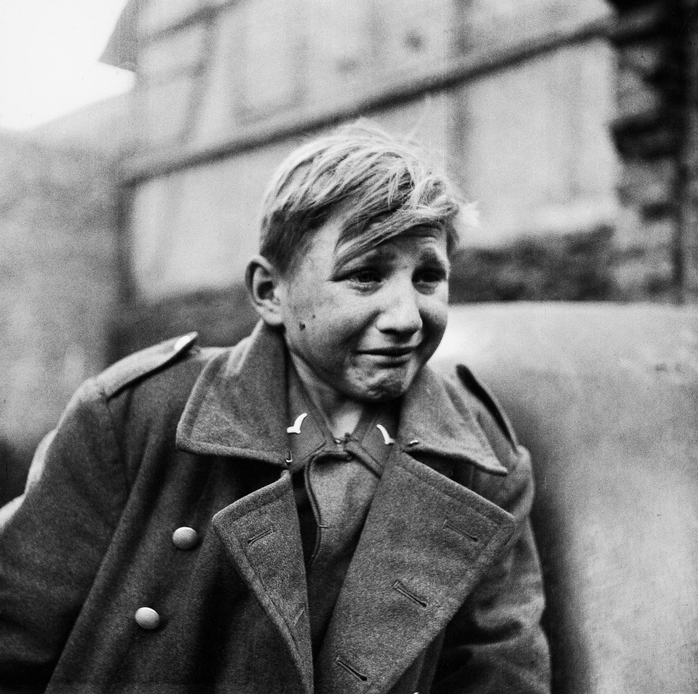 Fearful 15-year-old German Luftwaffe anti-aircraft crew member crying after being taken prisoner by American forces during the drive into Germany.