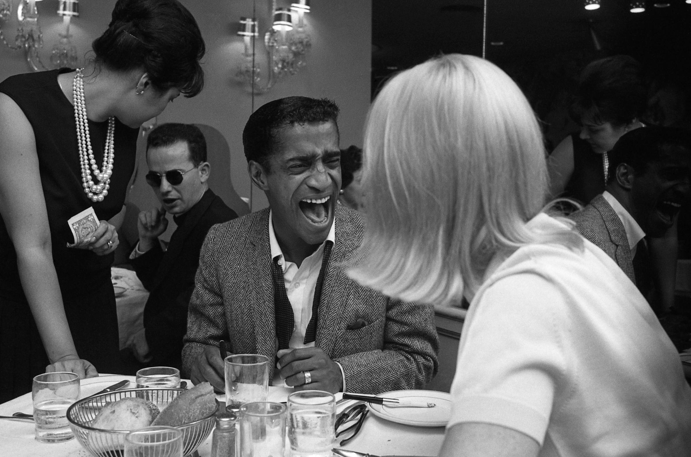 Sammy Davis Jr. laughs over dinner with his then-wife, Swedish actress May Britt.