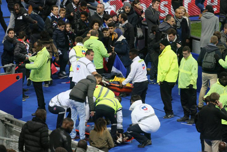 Crowds wait on the pitch during a soccer match at Stade de France on Nov. 13, 2015 in Paris, after the game was halted following an explosion.