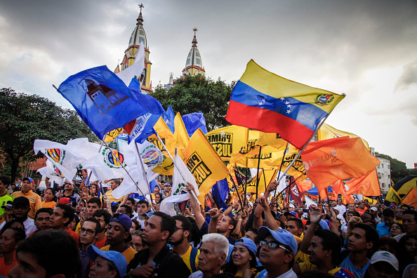 Attendees gather and wave flags during the kick off campaign for opposition candidates in the El Paraiso sector of Caracas, Venezuela, on Nov. 14, 2015 (Wilfredo Riera—Bloomberg/Getty Images)