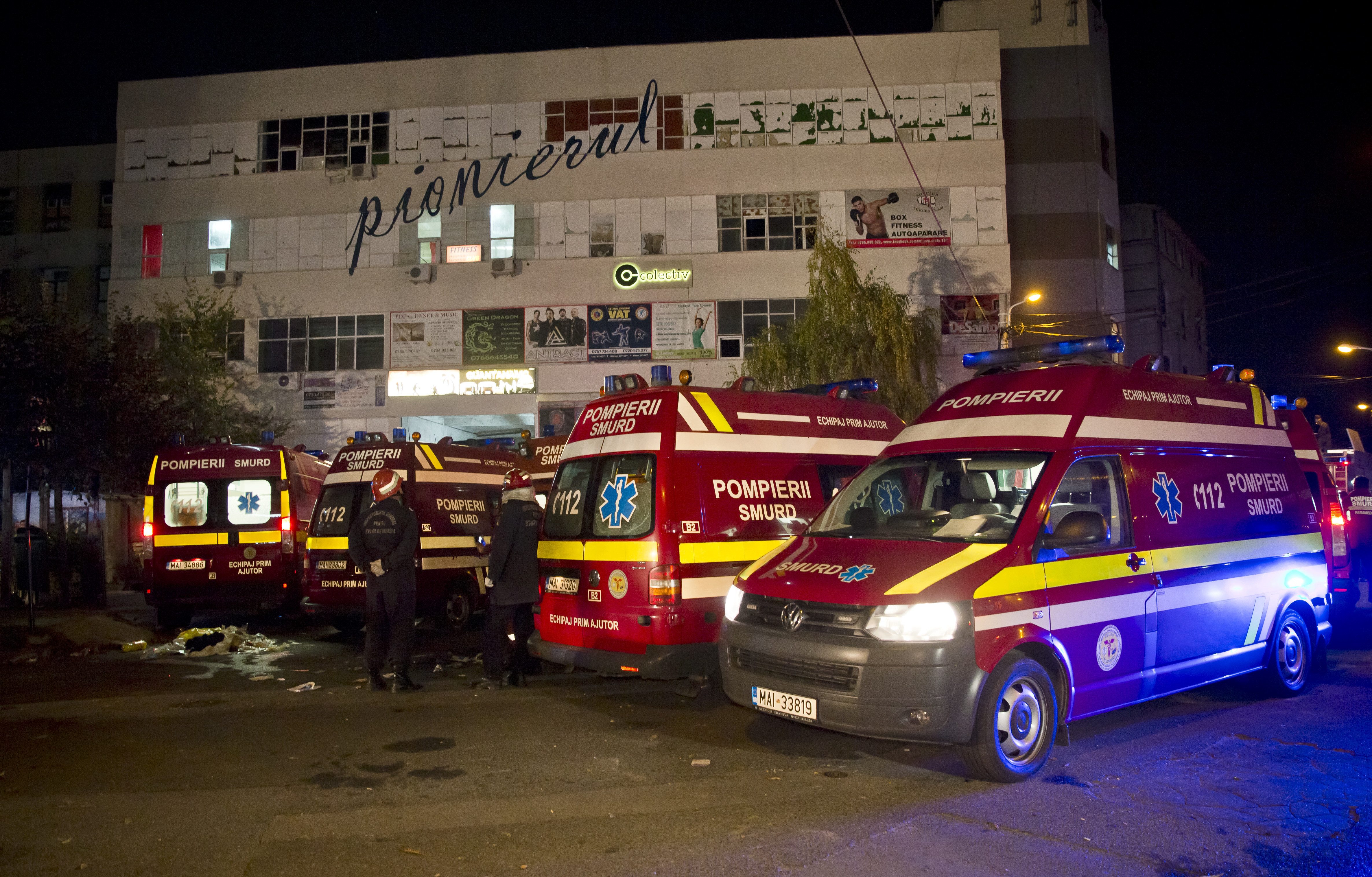 Ambulances are parked outside the site of a fire that occurred in a club, housed by the building in the background, in Bucharest. (Vadim Ghirda—AP)