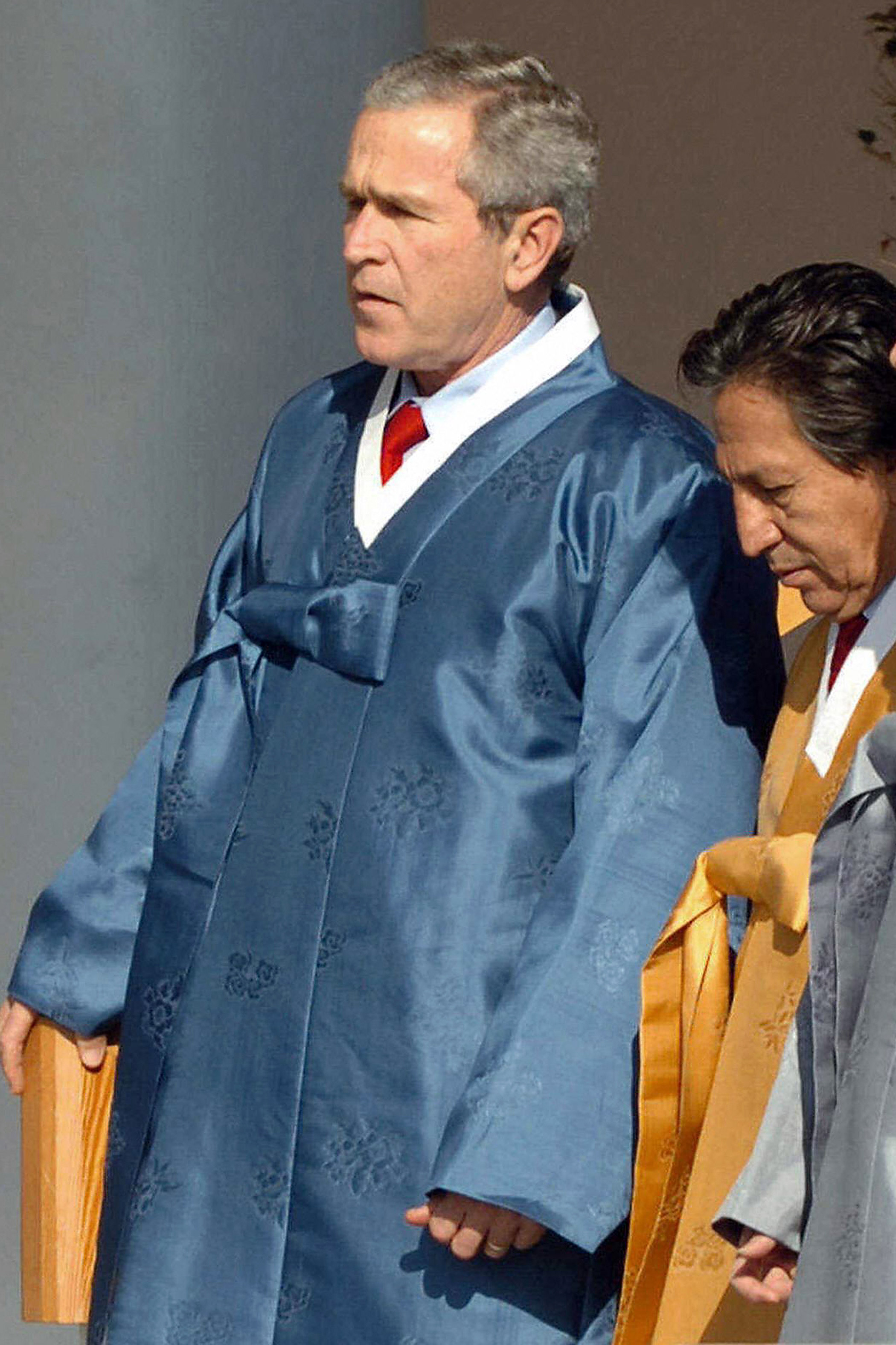 Clad in traditional South Korean outfits, U.S. President George W. Bush and Peruvian President Alejandro Toledo proceed to a photo session during the APEC Summit in Pusan, South Korea on Nov. 19, 2005.