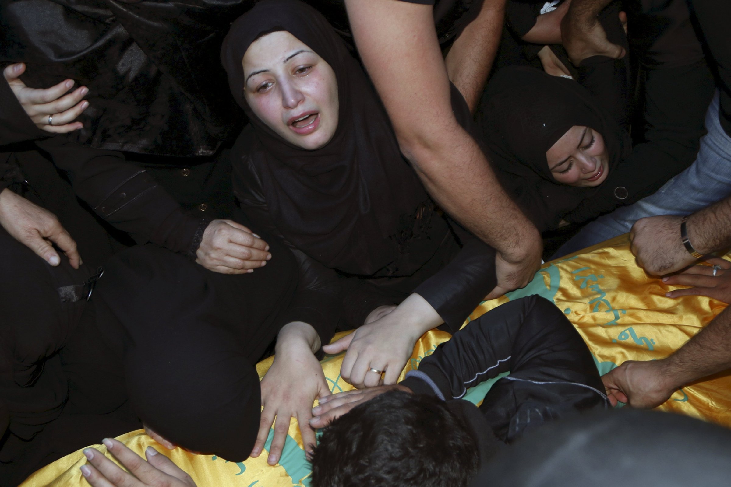 Relatives mourn over the coffin of Hezbollah member, Adel Akram Termos, who was killed in the two explosions that occurred on Thursday in Beirut's southern suburbs, during his funeral in Tallousa village, southern Lebanon on Nov. 13, 2015.