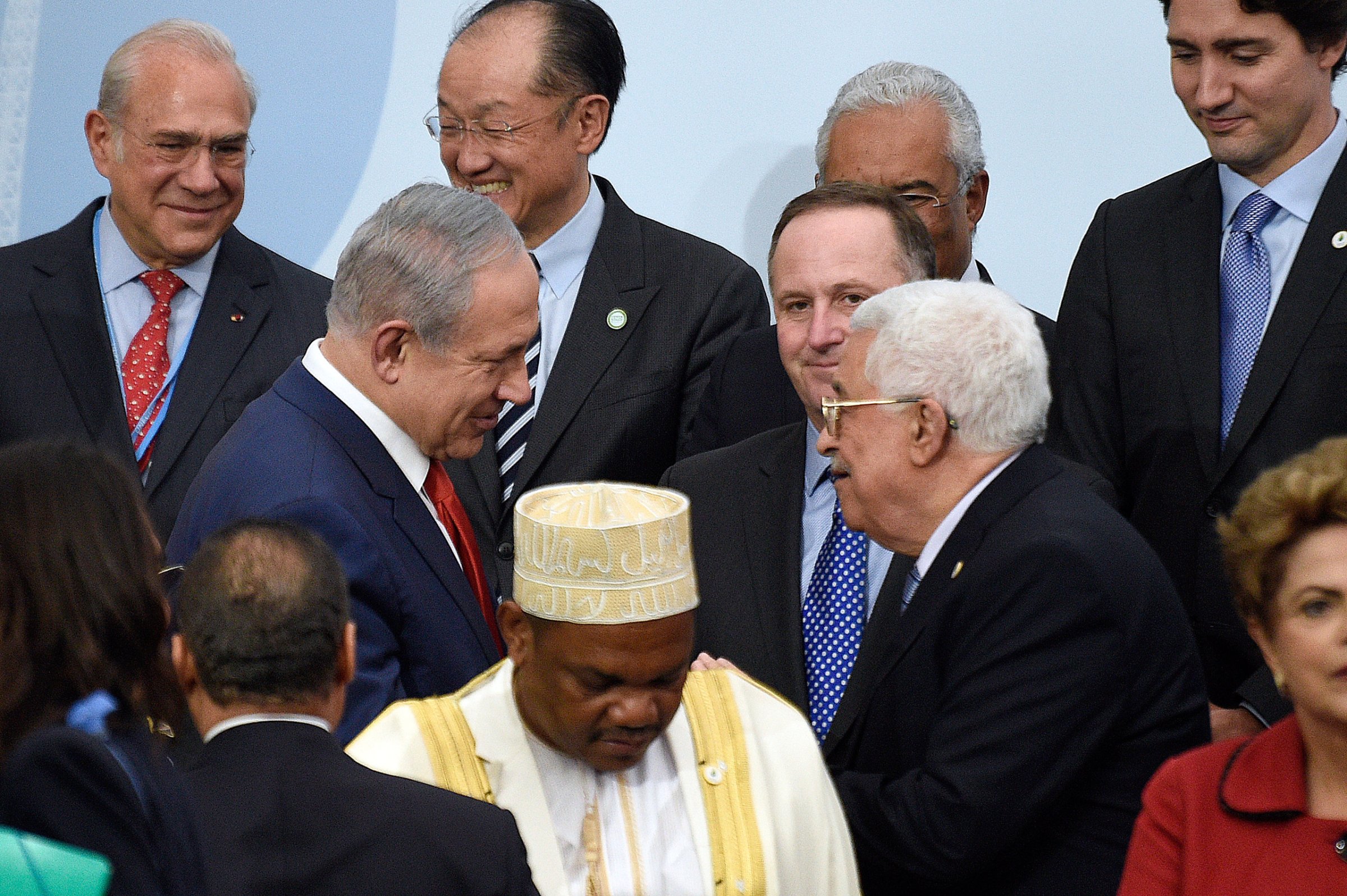 Israeli Prime Minister Benjamin Netanyahu, center left, talks with Palestinian President Mahmoud Abbas, center right, as they wait to pose for a group photo as part of the COP21, the United Nations Climate Change Conference, in Le Bourget, outside Paris, Monday, Nov. 30, 2015. More than 150 world leaders are meeting under heightened security, for the 21st Session of the Conference of the Parties to the United Nations Framework Convention on Climate Change (COP21/CMP11), also known as "Paris 2015" from November 30 to December 11. (Martin Bureau/Pool Photo via AP)