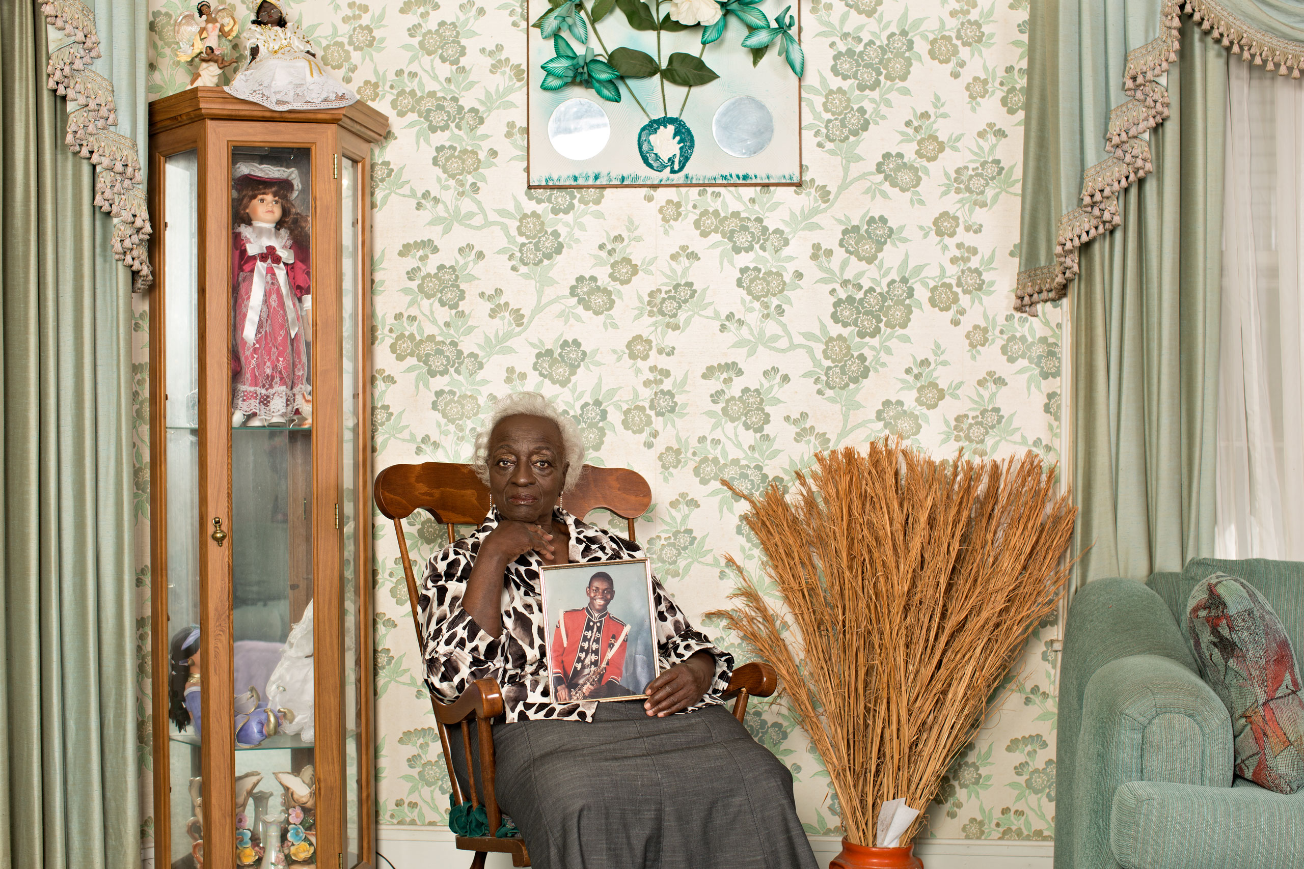 Gracie BroomeThe Rev. Clementa Pinckney’s grandmother at her home in Mullins, S.C., with a photo of him in his school marching-band uniform. “When you hear others forgiving,” she says, “it makes you feel good.”