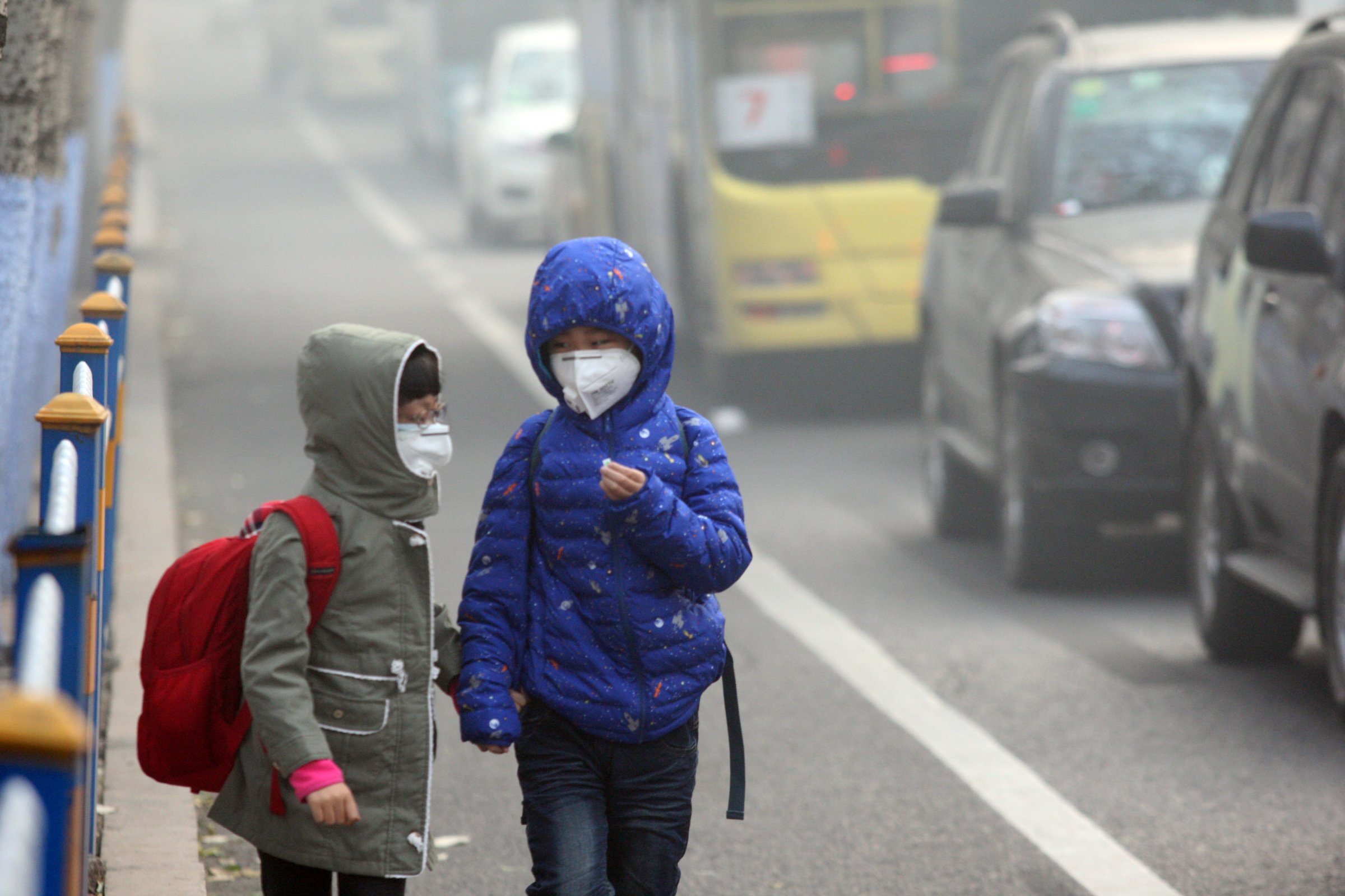 HARBIN, CHINA - NOVEMBER 03: (CHINA OUT) Two children wearing face masks walk in heavy smog on November 3, 2015 in Harbin, Heilongjiang Province of China. Heavy smog stroke northeast China with the visibility in parts of cities reaching less than 50 meters. (Photo by ChinaFotoPress)***_***