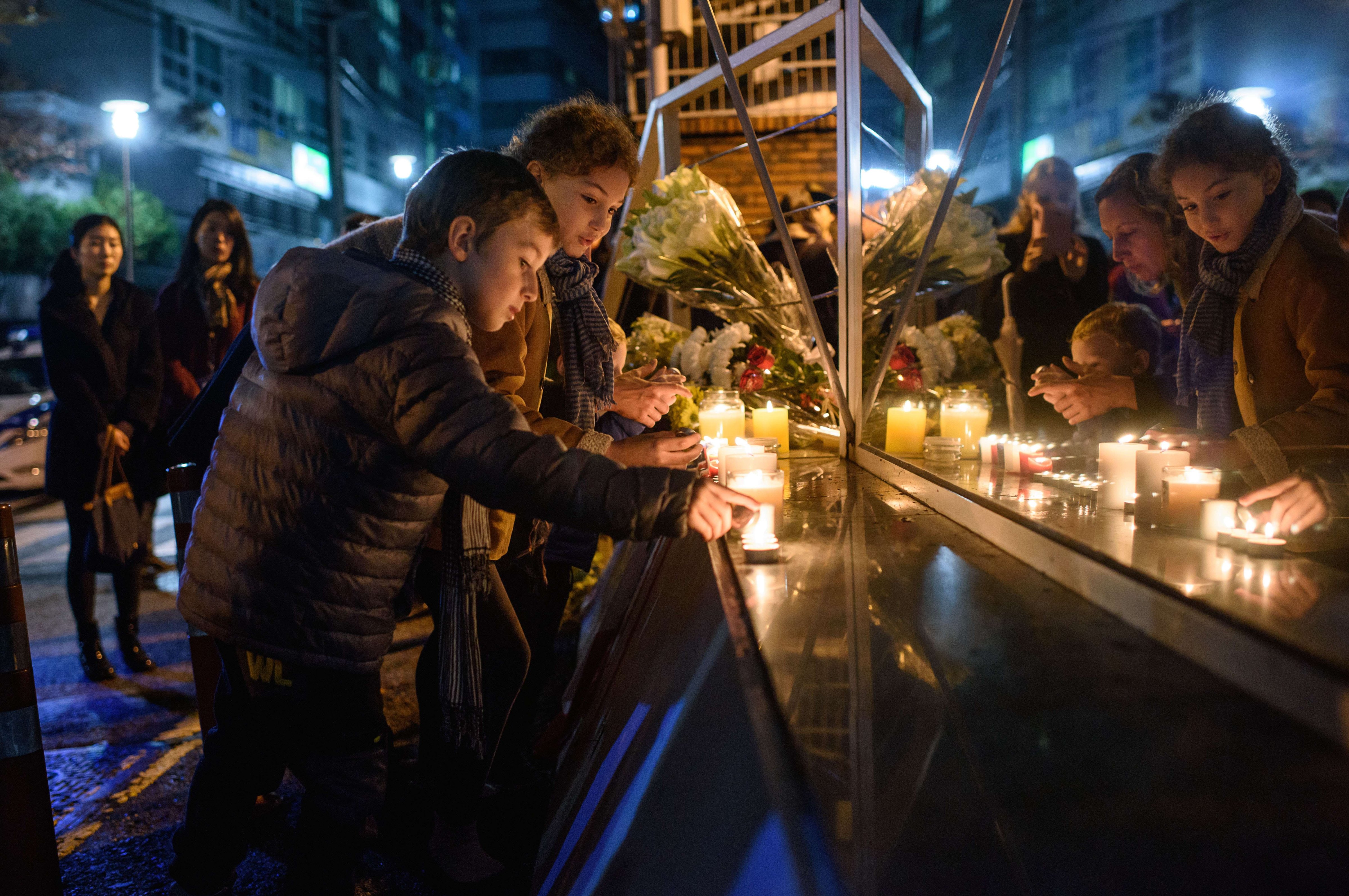Members of the French community living in South Korea light candles at a vigil outside the French embassy in Seoul on Nov. 14, 2015. (Ed Jones—AFP/Getty Images)