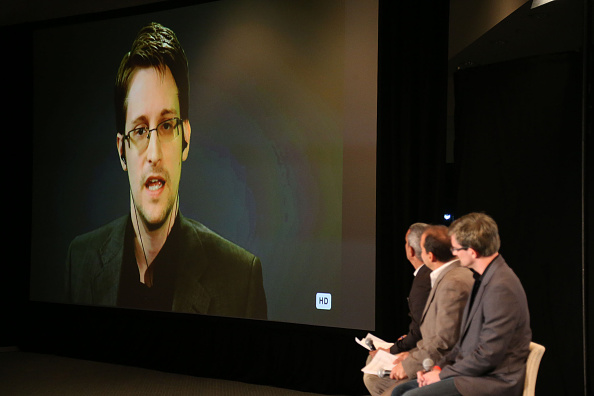 Edward Snowden on monitor speaks to panelist (L-R) Andy Bichlbaum, Mike Bonanno and actor David Neal during Politicon at the Los Angeles Convention Center on October 10, 2015 in Los Angeles, California.