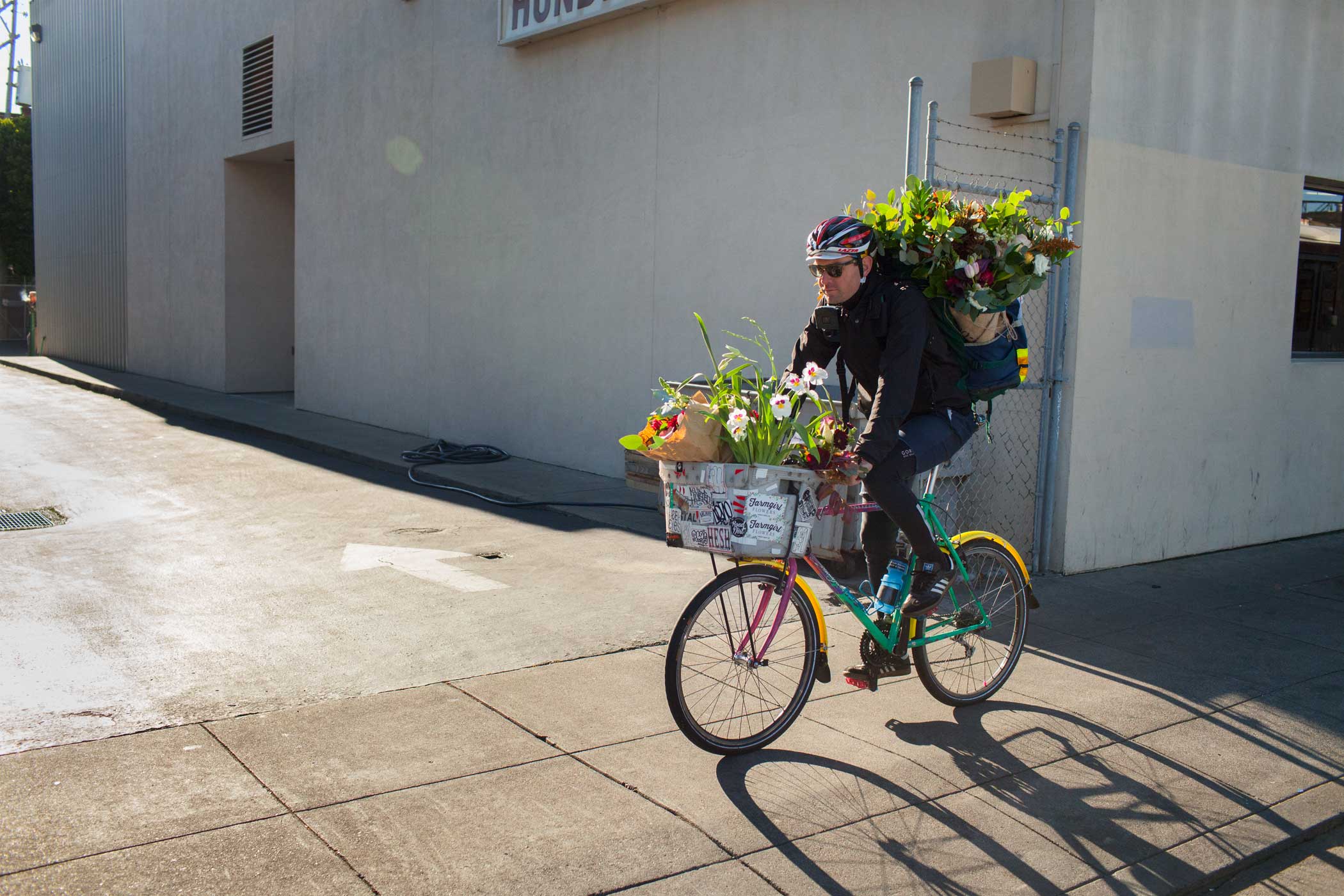 A flower delivery employee bikes to deliver his first flowers of the day.
