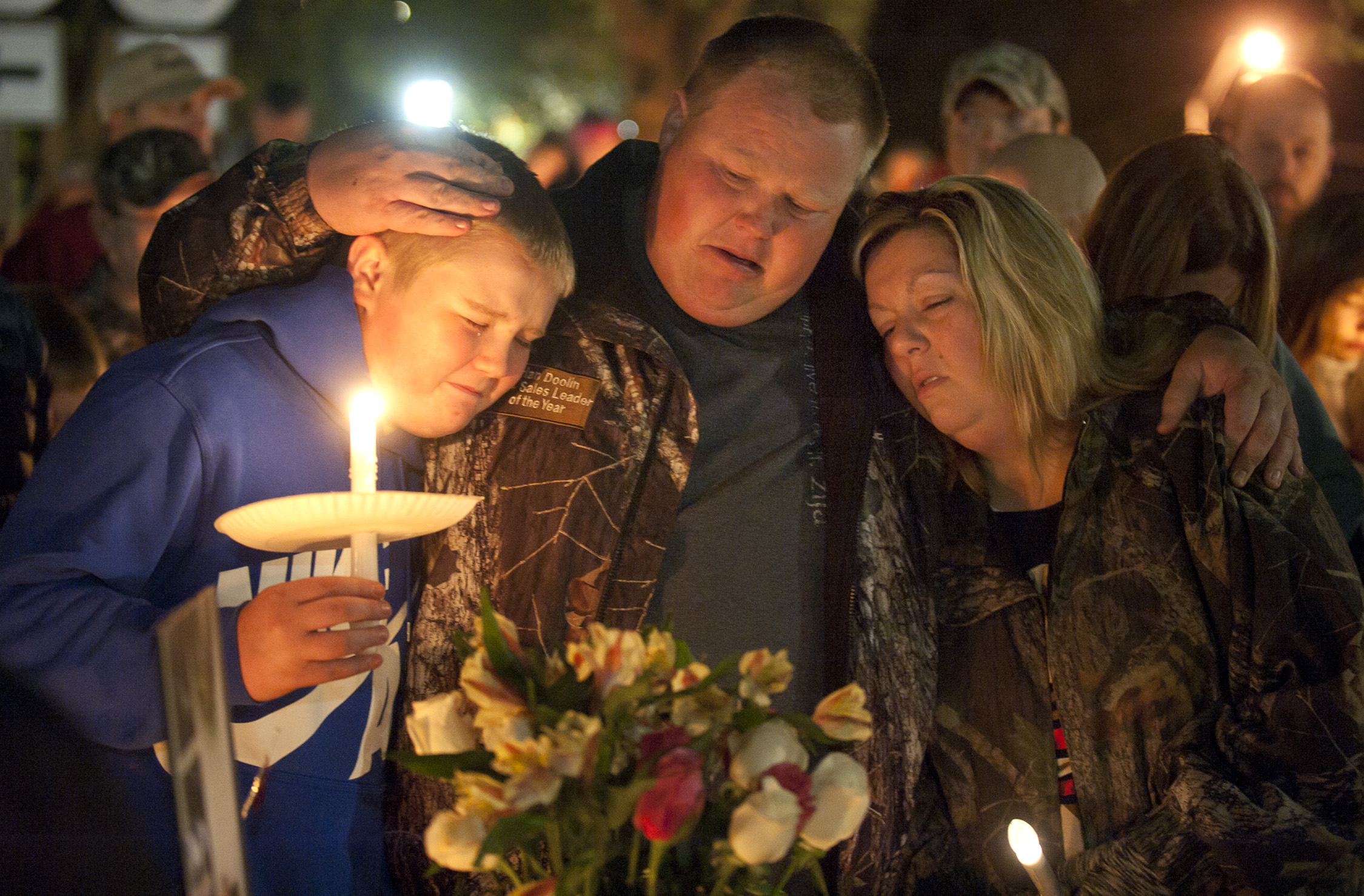 Gabriella Doolin's brother Alec, father Brian and mother Amy, comfort each other during a vigil for her in Scottsville, Kentucky on Nov. 15, 2015.