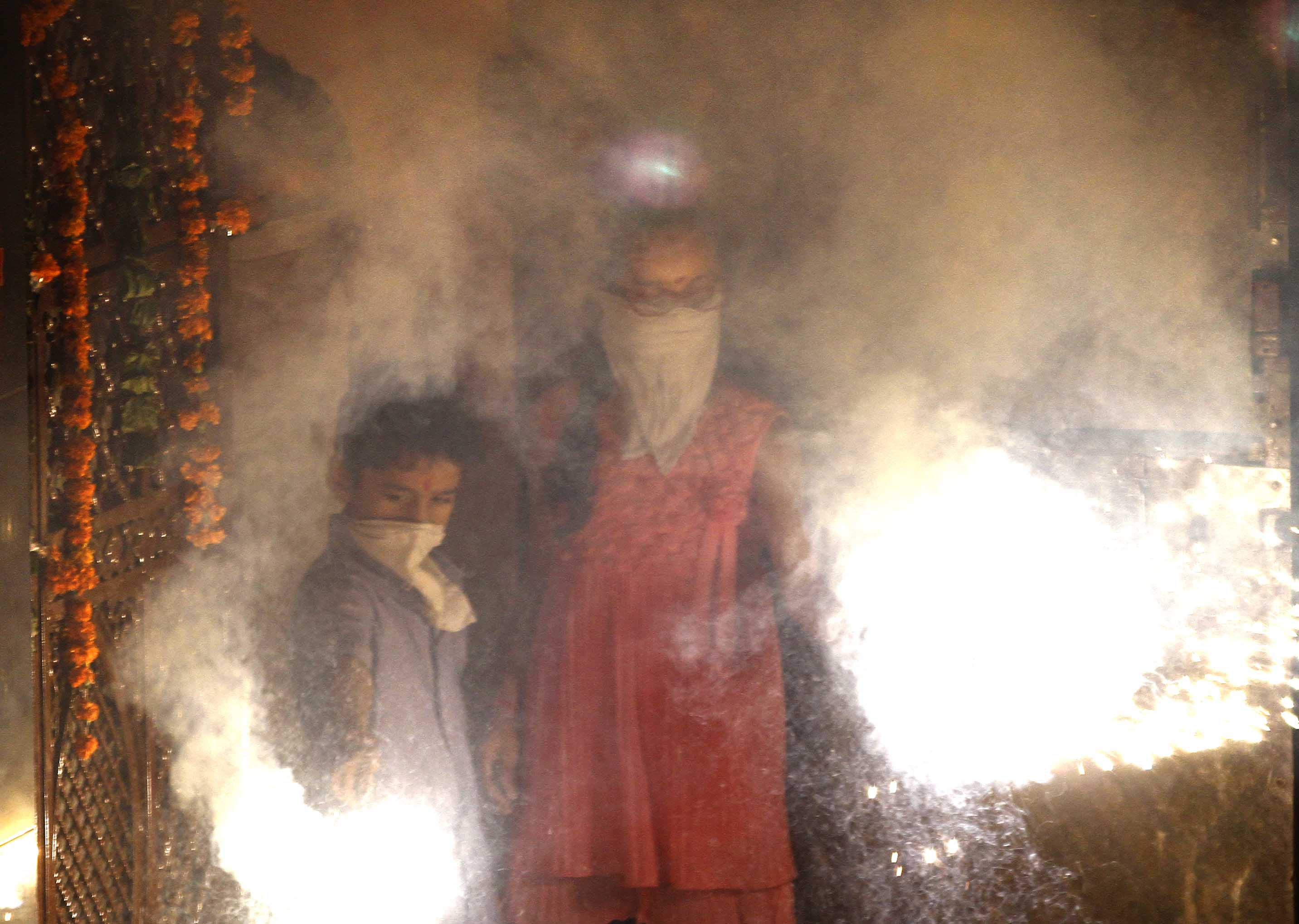 People bursting firecrackers as they celebrate Diwali, the Festival of Light, on Oct. 23, 2014, in New Delhi (Arun Sharma—Hindustan Times via Getty Images)