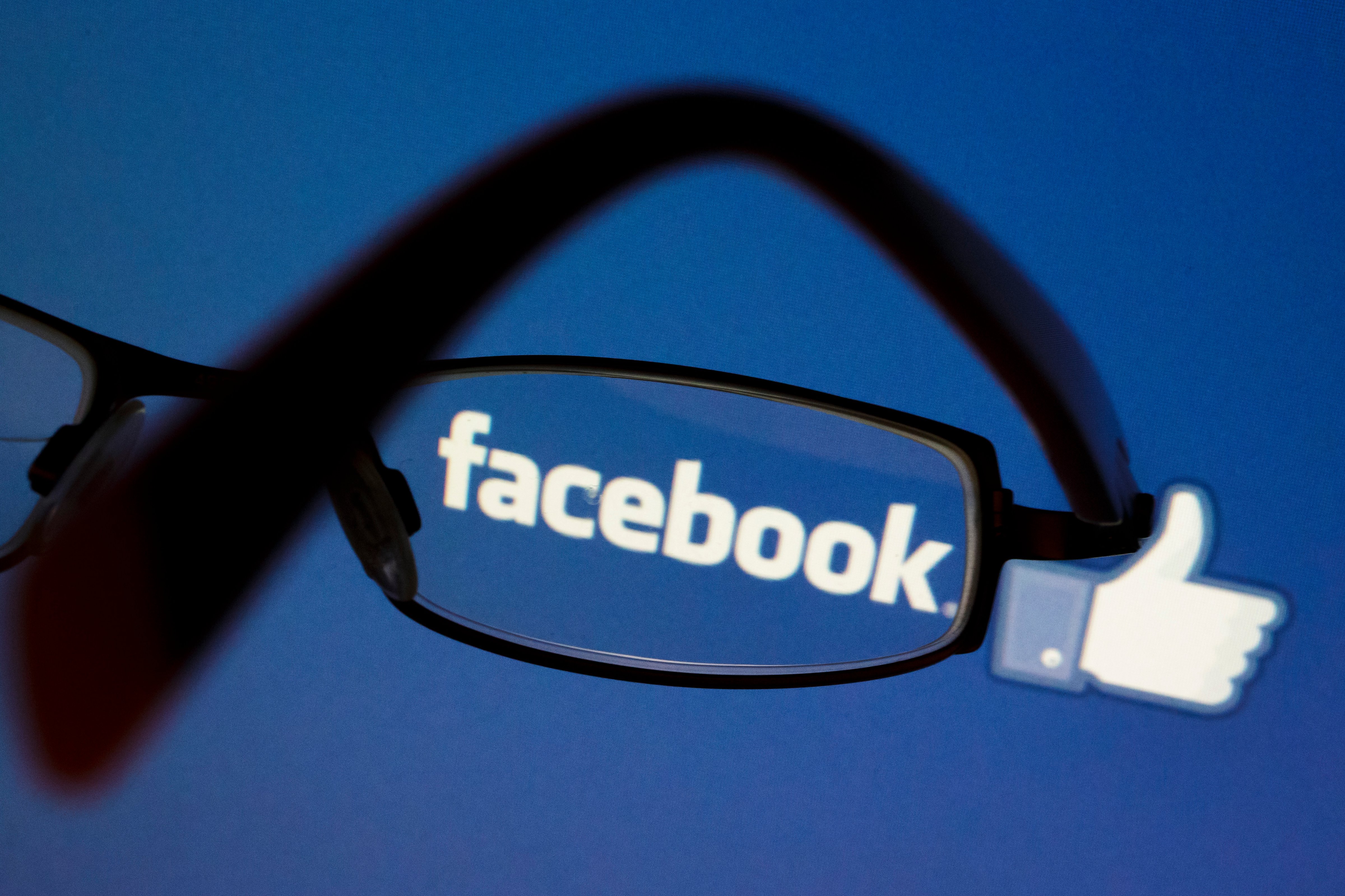 Posed scene on the topic facebook, glasses in front of the facebook logo on September 03, 2015 in Berlin, Germany. (Thomas Trutschel—Photothek/Getty Images)