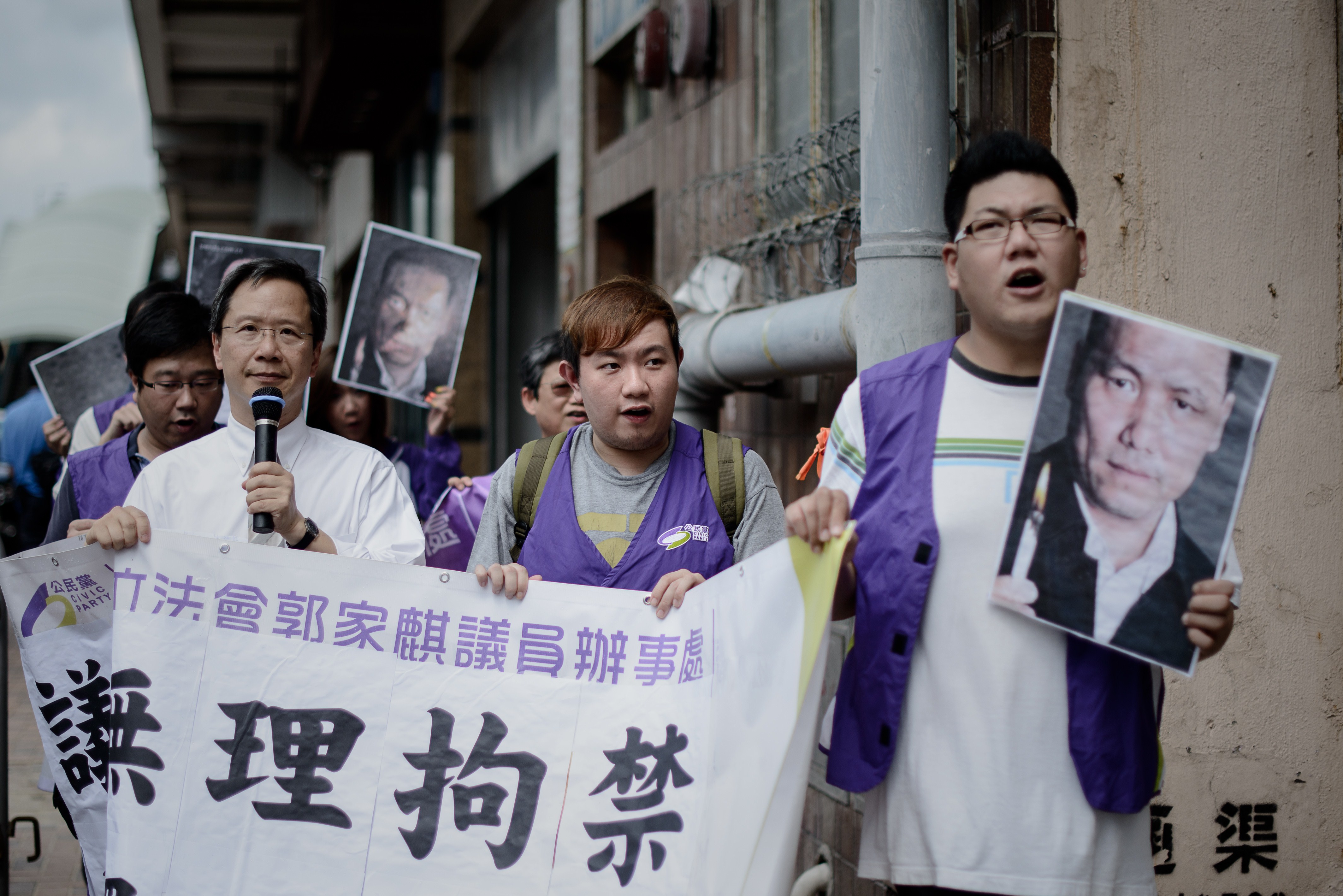 Protesters holding pictures of detained Chinese human-rights lawyer Pu Zhiqiang march to the Chinese Liaison Office in Hong Kong on May 14, 2014, asking for his release (Philippe Lopez—AFP/Getty Images)