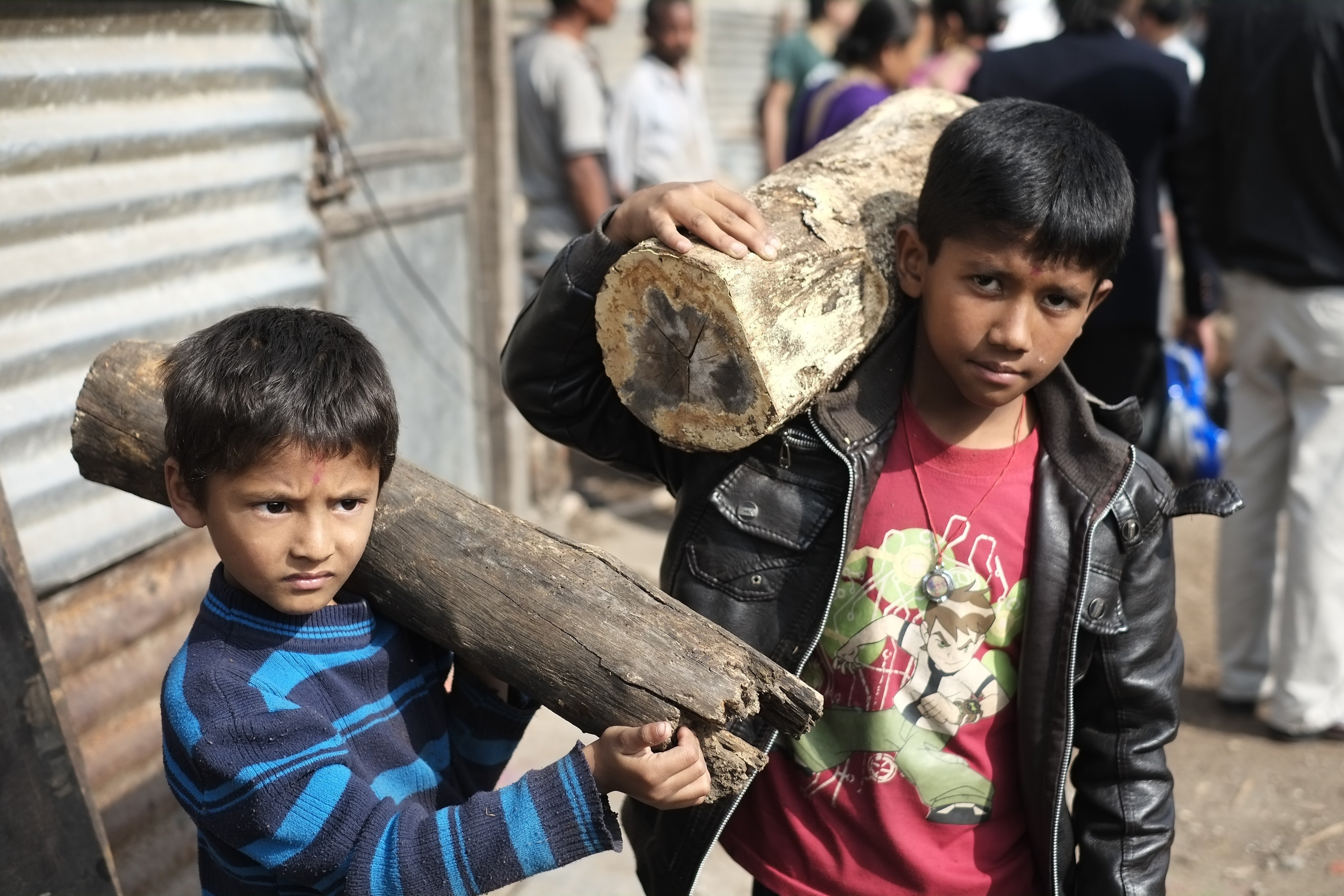 Nepalese boys carry firewood sold by the Nepal government in Kathmandu, Nepal on November 15, 2015. Nepal is facing fuel shortage due to a blockade by India as protests continue in the southern Terai region over the past three months. (Sunil Pradhan—Anadolu Agency/Getty Images)