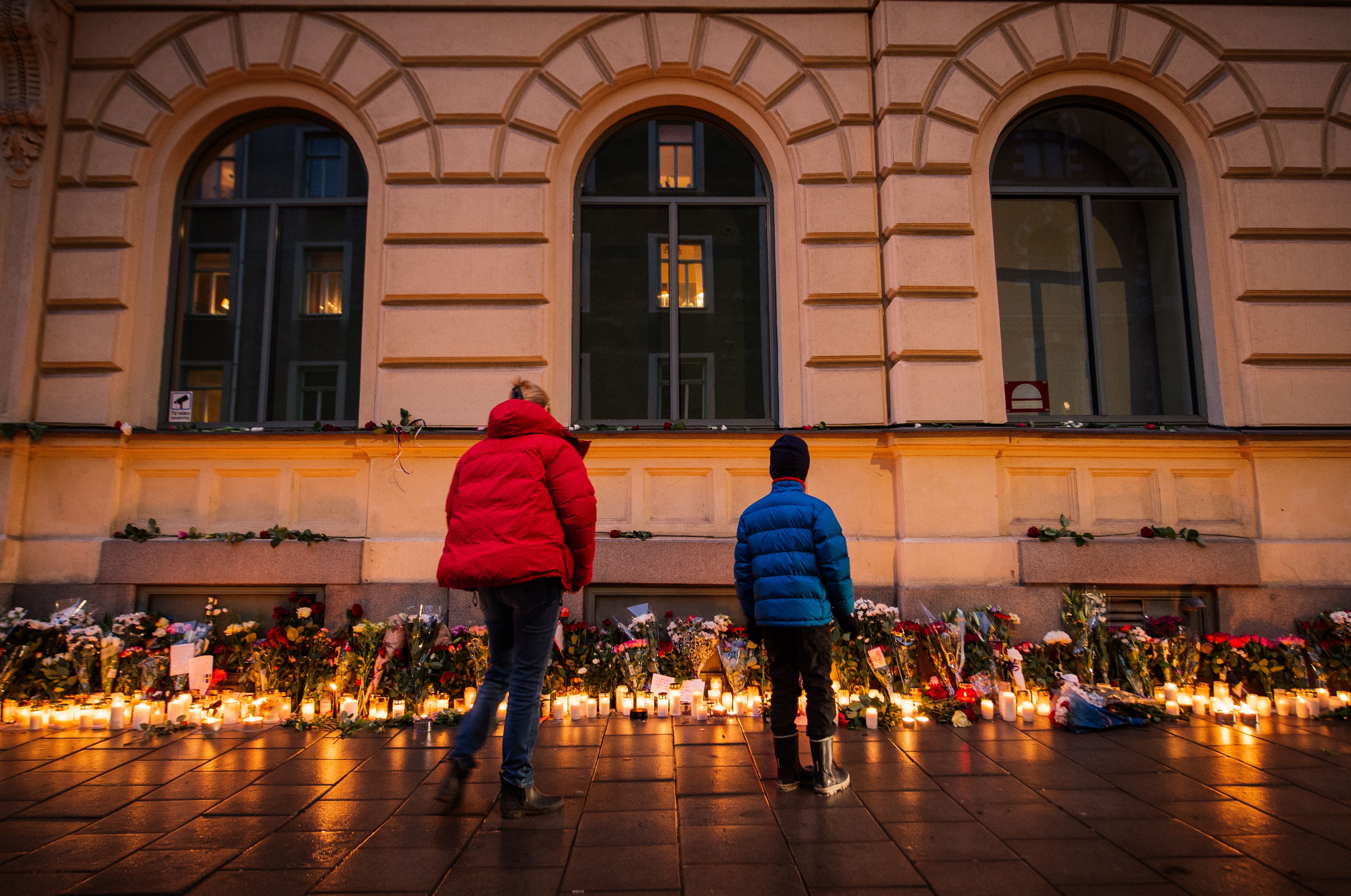 People look at candles and flowers placed outside the French embassy in Stockholm, on November 15, 2015, two days after the deadly attacks in Paris. (JONATHAN NACKSTRAND—AFP/Getty Images)