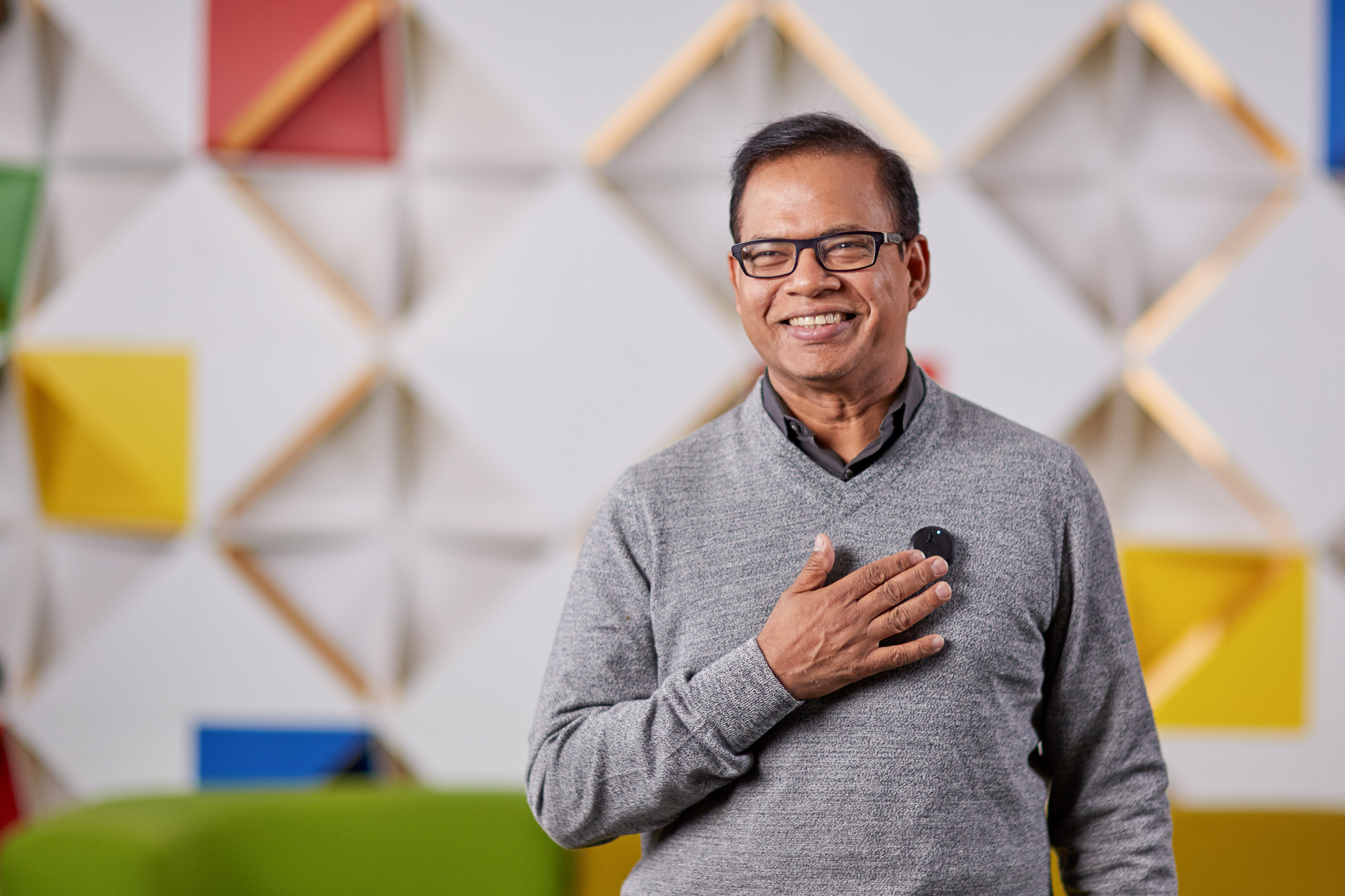 Amit Singhal, senior vice president and software engineer at Google, uses a prototype lapel pin modeled after the communicator badge from Star Trek. The device, which never left the testing phase, uses a microphone to listen to a user's voice and can use Bluetooth to send those commands to another device. (Google)