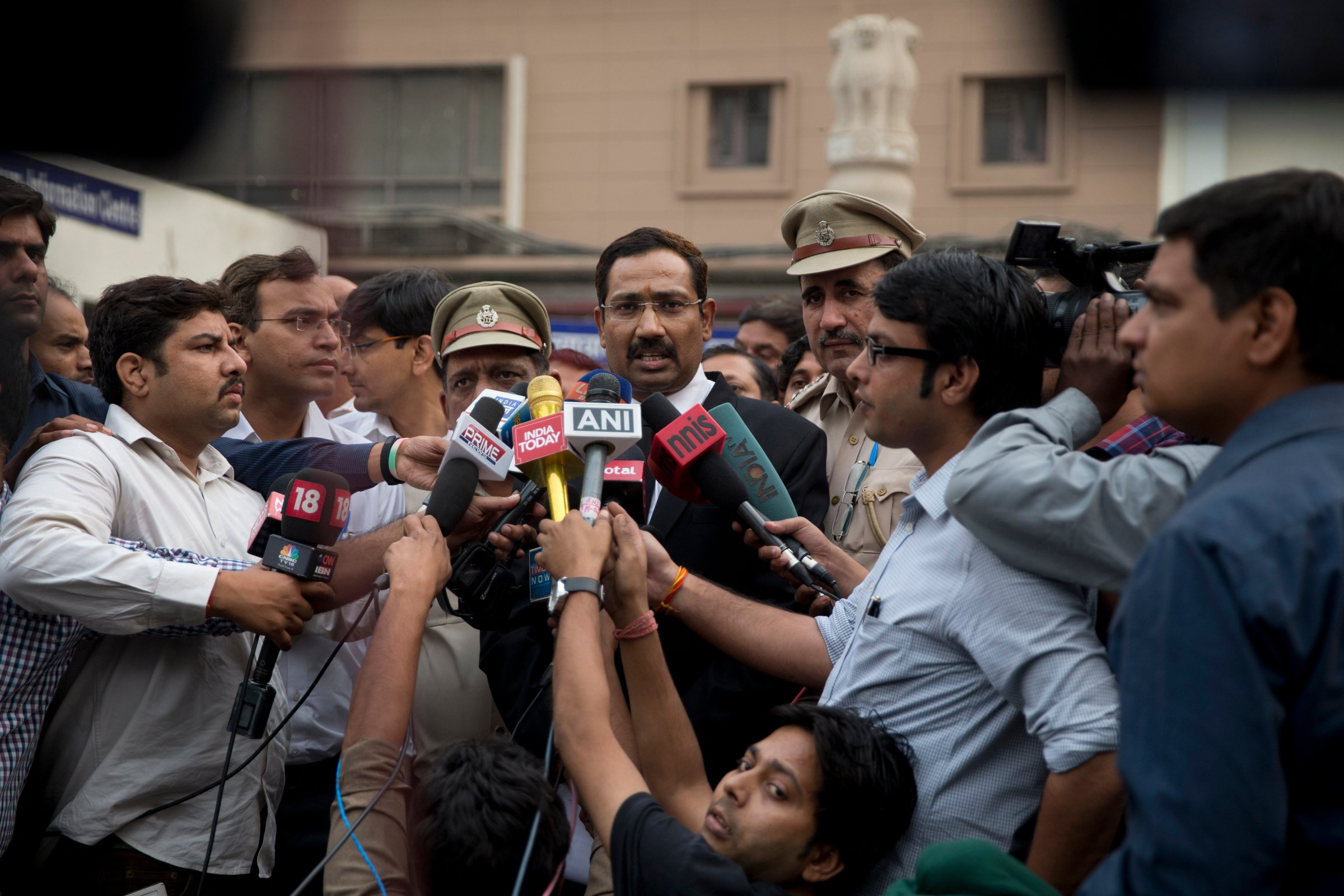A lawyer, center, speaks to reporters at the Tis Hazari Courts premises, after a court sentence for Uber driver Shiv Kumar Yadav in New Delhi on Tuesday, Nov. 3, 2015. An Indian court sentenced Uber driver Yadav to life in prison Tuesday for raping a passenger in his vehicle last December.