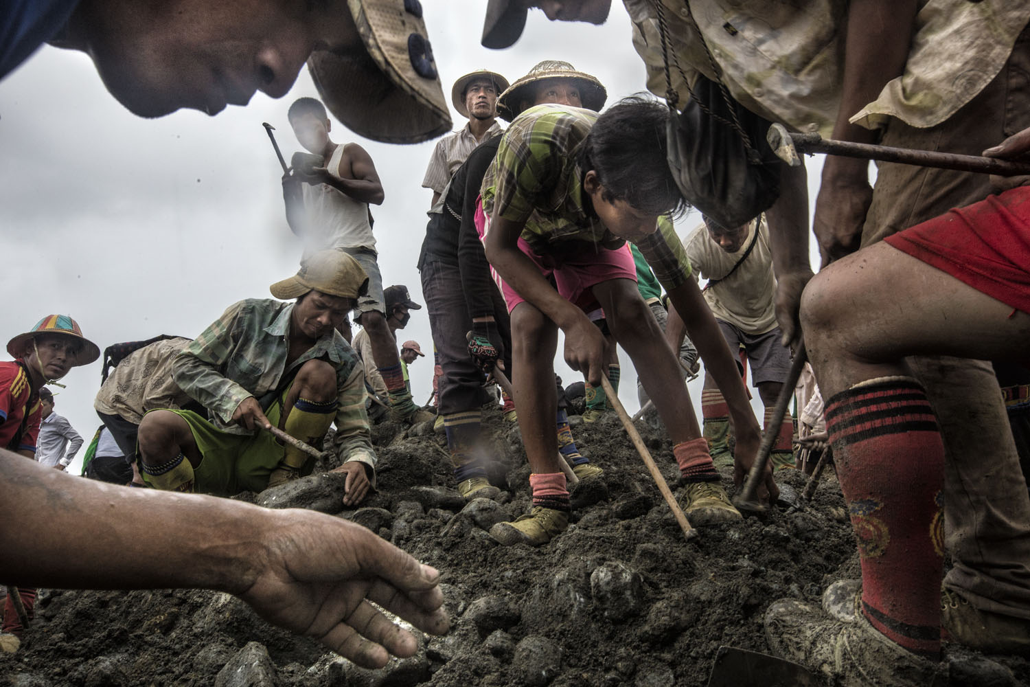 Freelance miners search for jade on a pile of earth-waste which is dumped by a mining company, Hpakant, Kachin State, Burma, June 2015
